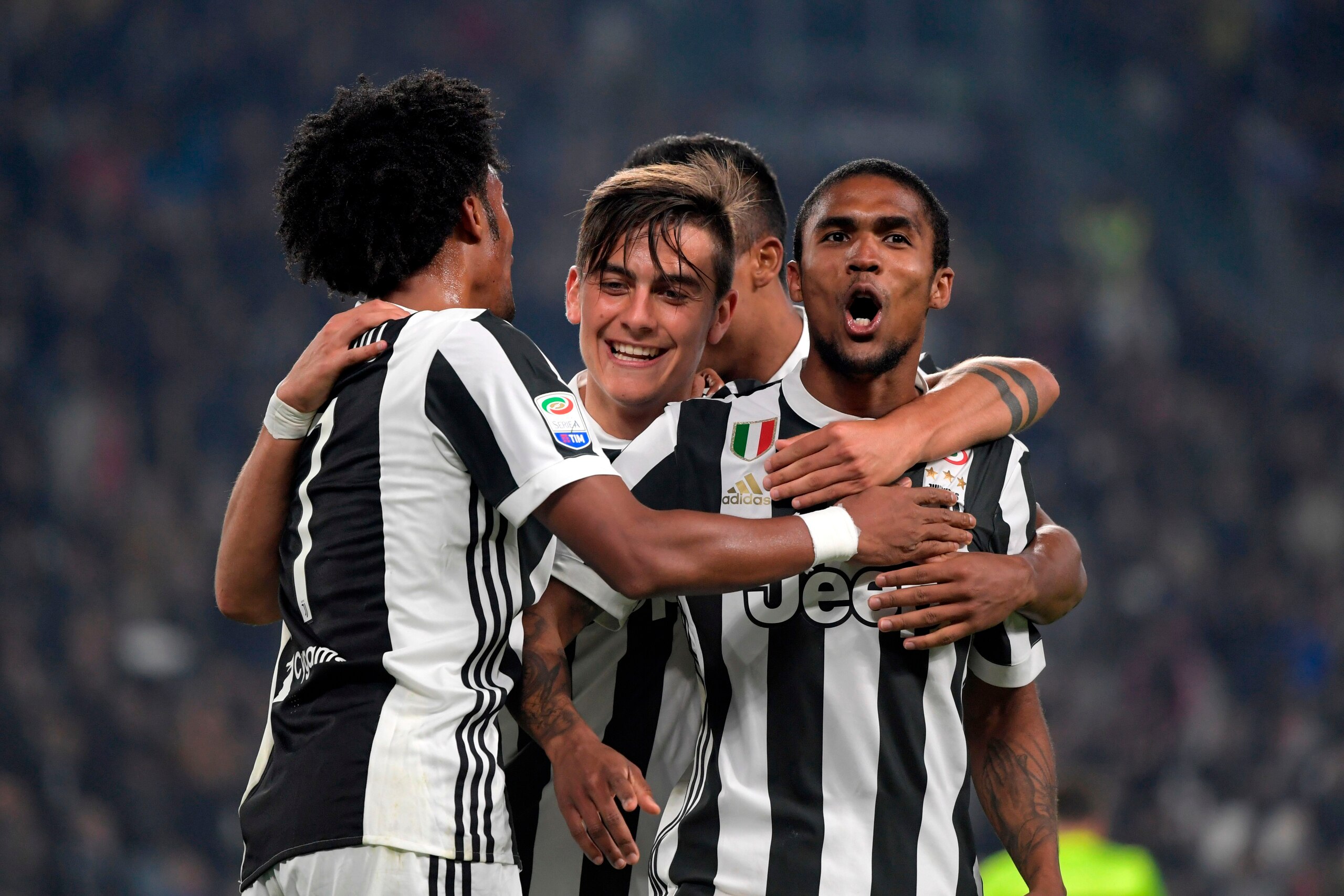 Juventus' Colombian forward Juan Cuadrado (L) celebrates with Juventus' Argentinian forward Paulo Dybala (C) and Juventu's Brazilian forward Douglas Costa de Souza after scoring during the Italian Serie A football match Juventus vs Spal  at the Allianz st