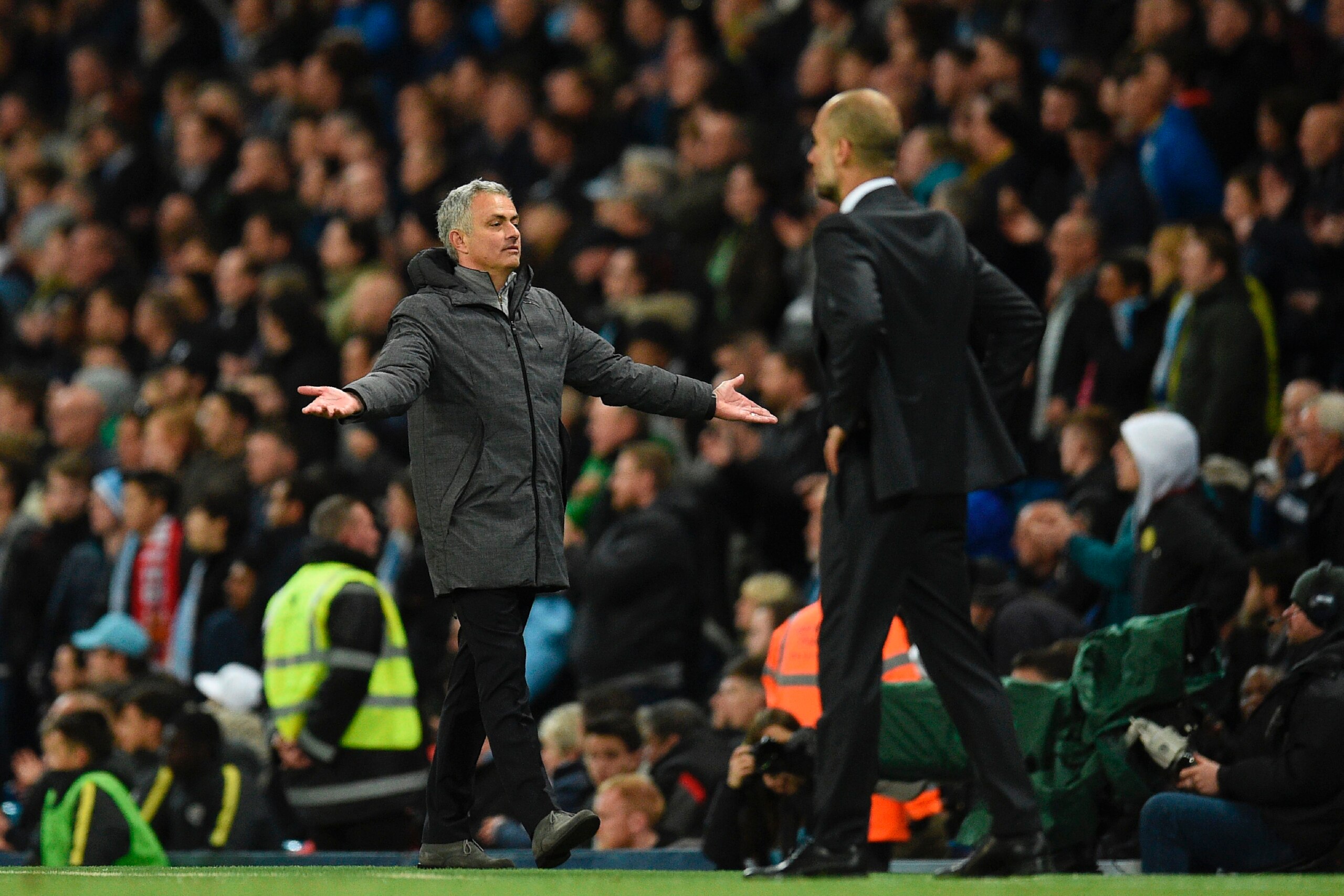 Manchester United's Portuguese manager Jose Mourinho (L) reacts on the touchline next to Manchester City's Spanish manager Pep Guardiola (R) during the English Premier League football match between Manchester City and Manchester United at the Etihad Stadi