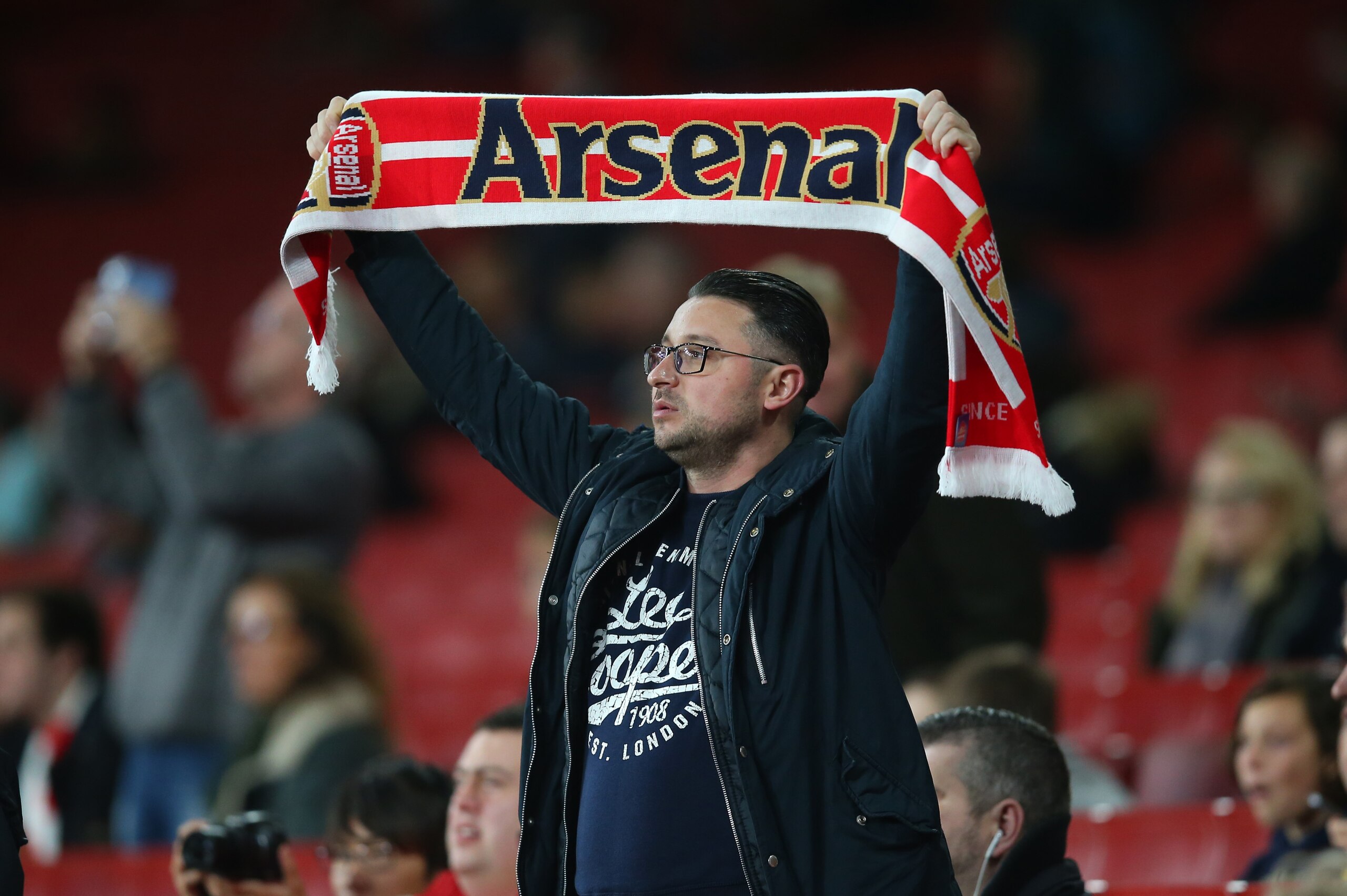 LONDON, ENGLAND - OCTOBER 24: A fan of Arsenal holds up a scarf before the Carabao Cup Fourth Round match between Arsenal and Norwich City at Emirates Stadium on October 24, 2017 in London, England. (Photo by Catherine Ivill - AMA/Getty Images)
