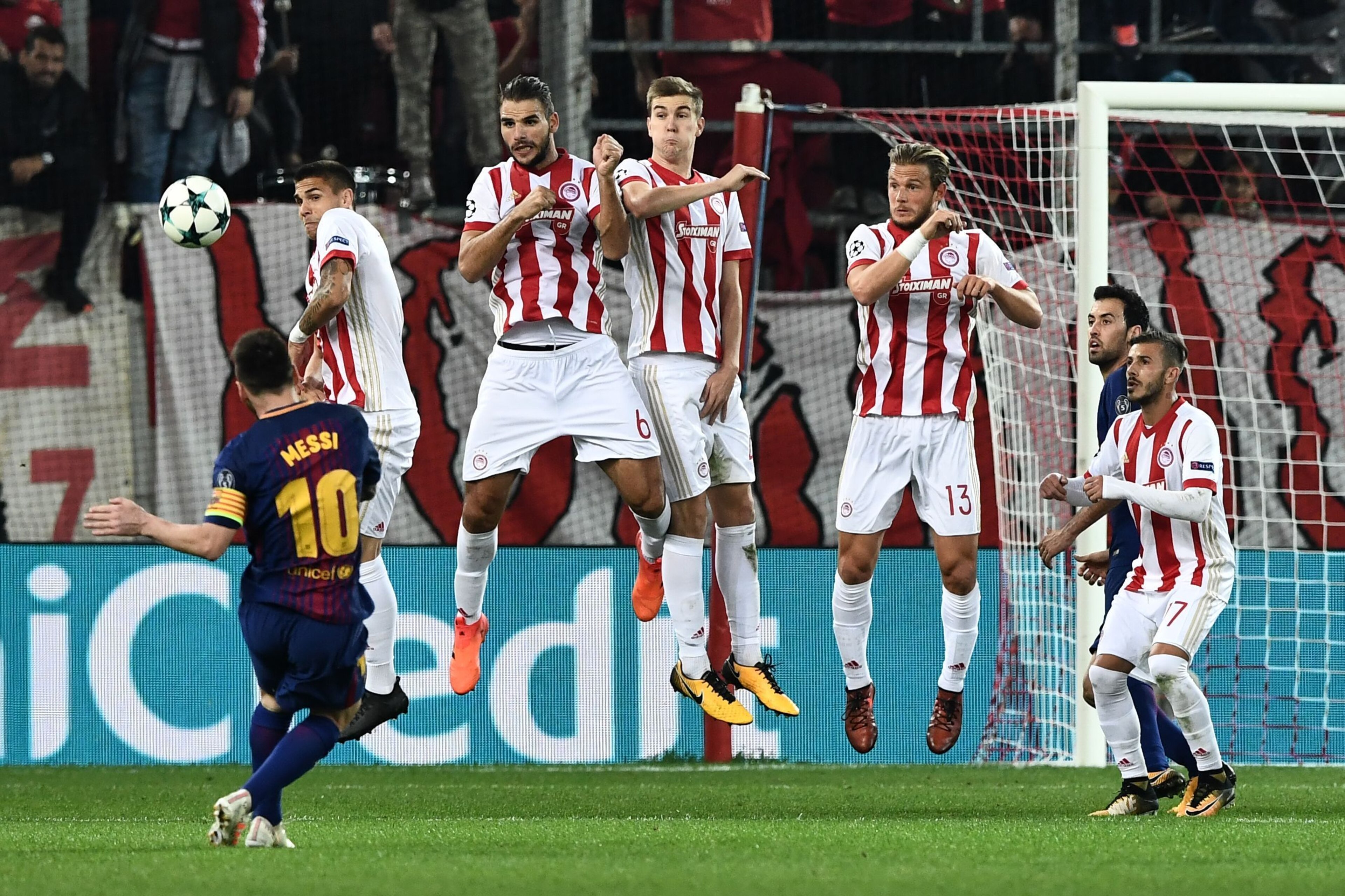 Barcelona's Argentinian forward Lionel Messi (L) kicks the ball in front of Olympiakos players during the UEFA Champions League group D football match between FC Barcelona and Olympiakos FC at the Karaiskakis stadium in Piraeus near Athens on October 31, 