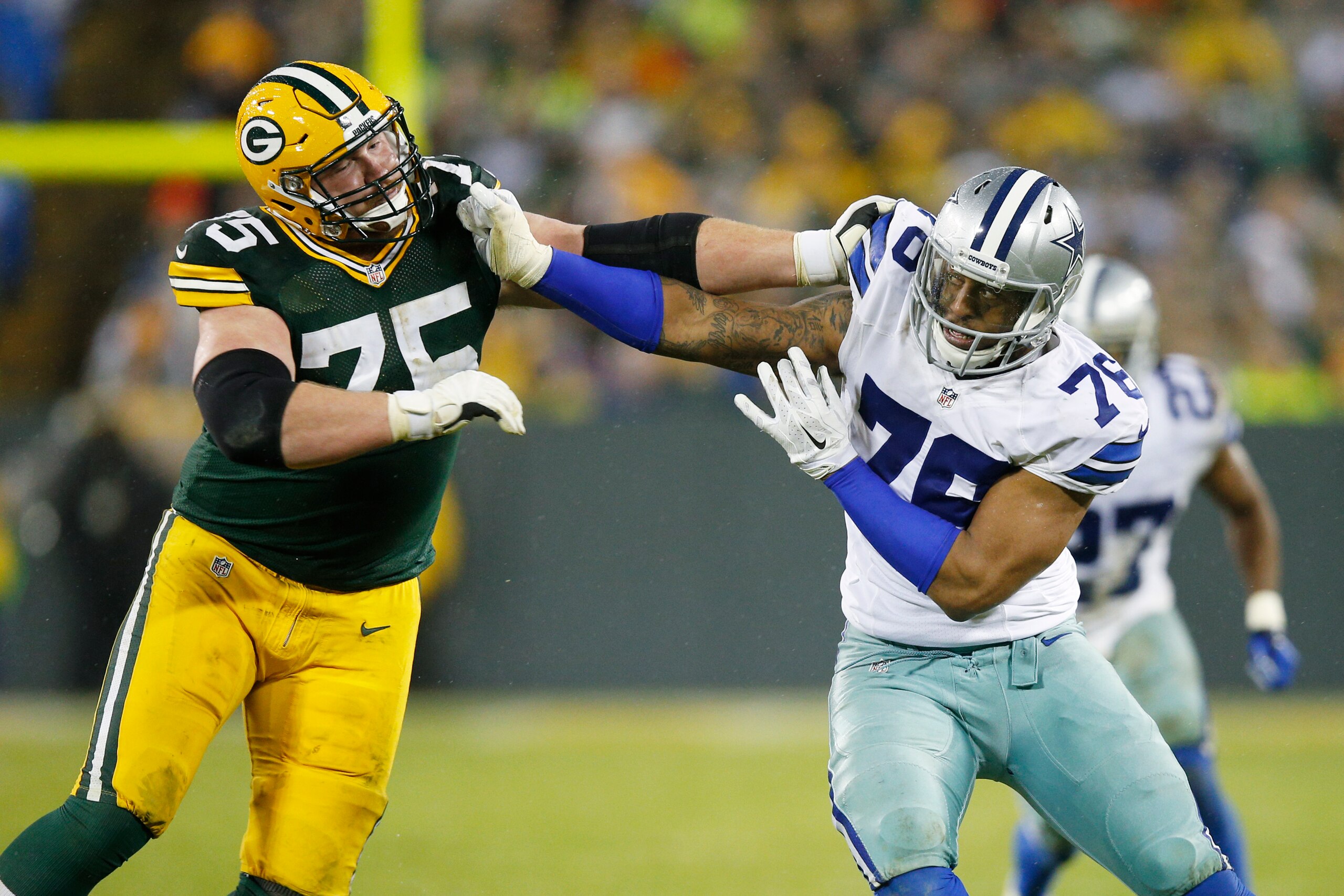 GREEN BAY, WI - DECEMBER 13: Greg Hardy #76 of the Dallas Cowboys rushes against Bryan Bulaga #75 of the Green Bay Packers during the game at Lambeau Field on December 13, 2015 in Green Bay, Wisconsin. The Packers defeated the Cowboys 28-7. (Photo by Joe 