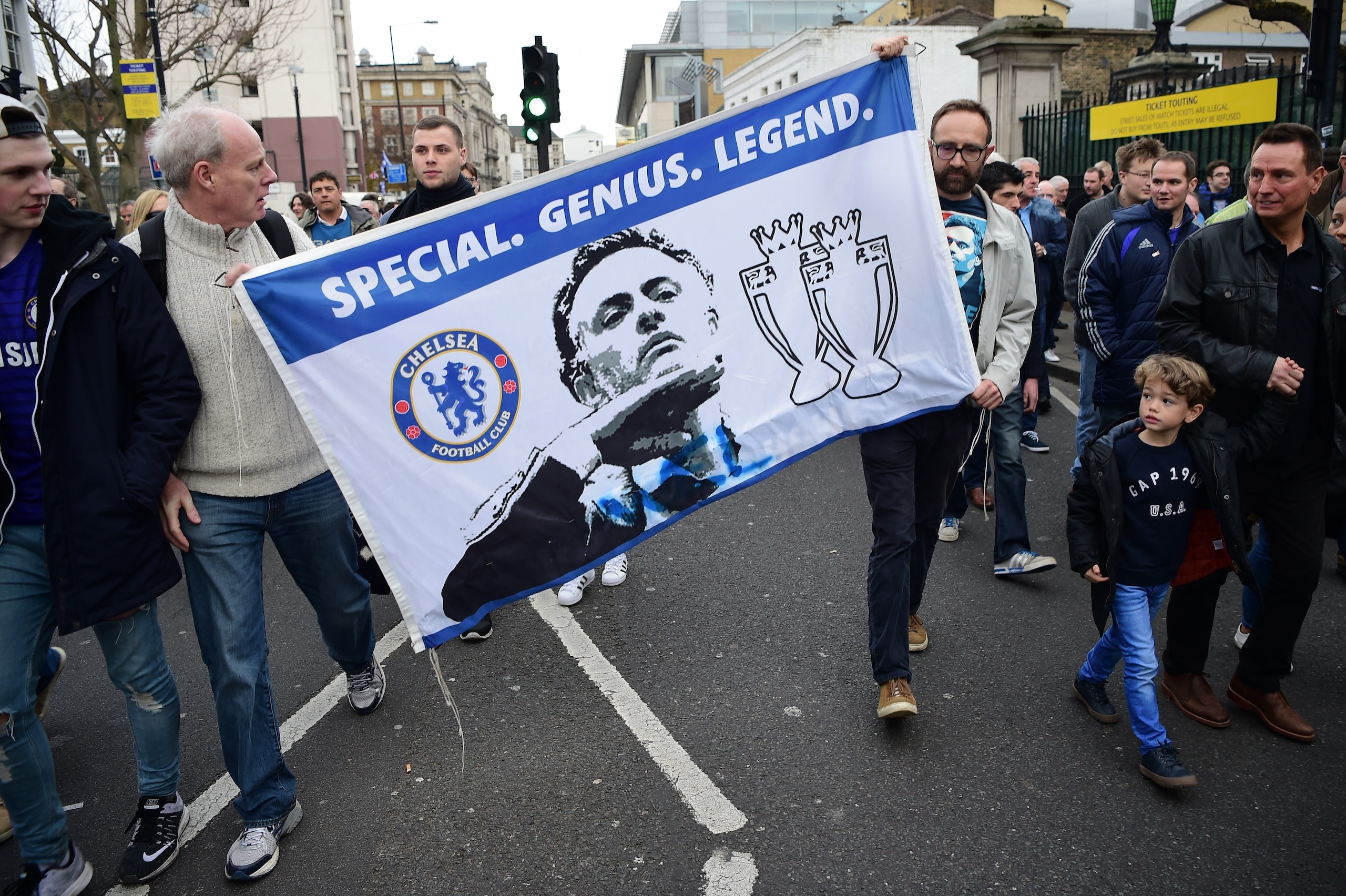 Supporters carry a flag in support of Chelsea's former Portuguese manager Jose Mourinho before the English Premier League football match between Chelsea and Sunderland at Stamford Bridge in London on December 19, 2015. Jose Mourinho attended the Champions