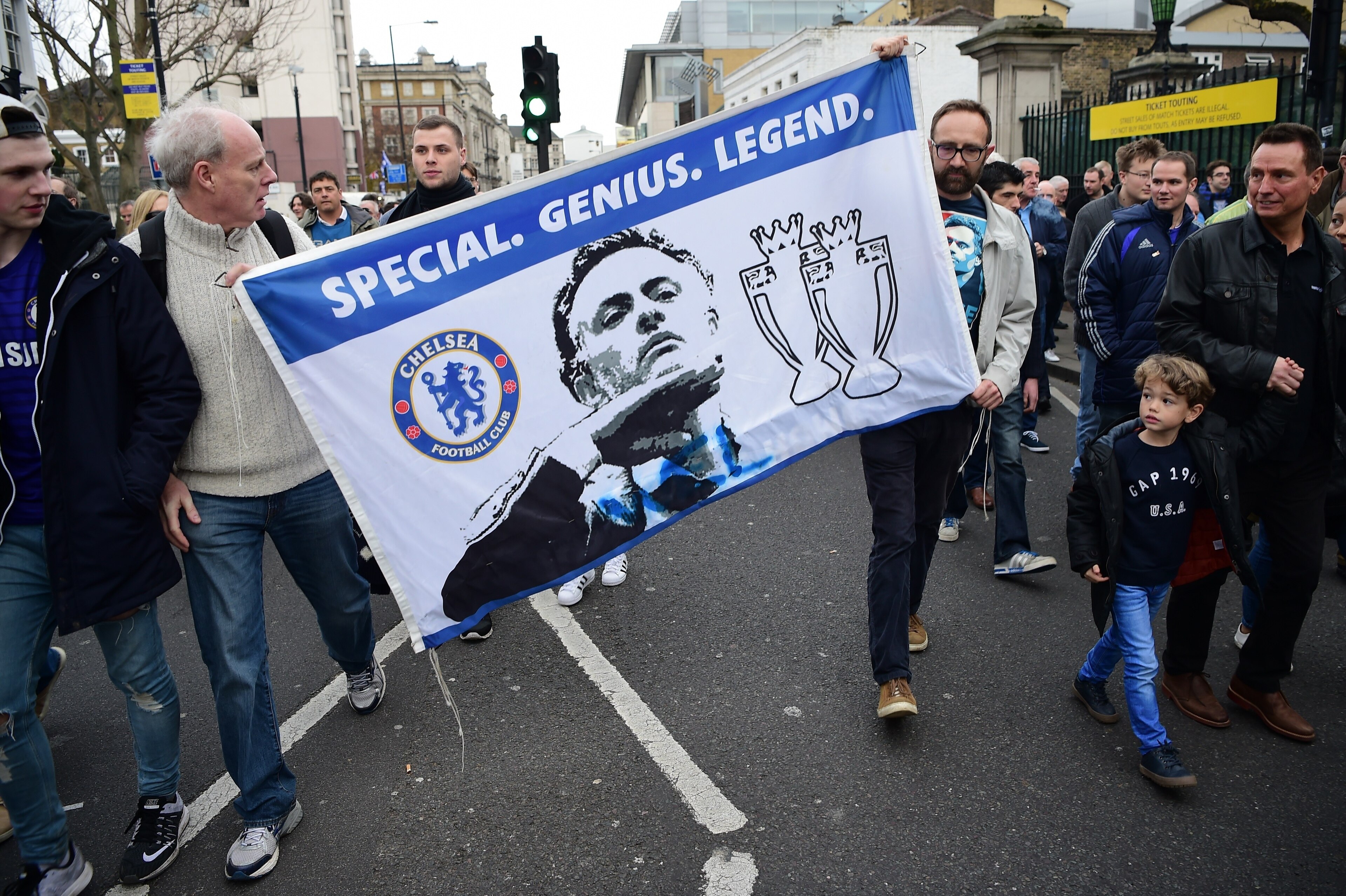 Supporters carry a flag in support of Chelsea's former Portuguese manager Jose Mourinho before the English Premier League football match between Chelsea and Sunderland at Stamford Bridge in London on December 19, 2015. Jose Mourinho attended the Champions