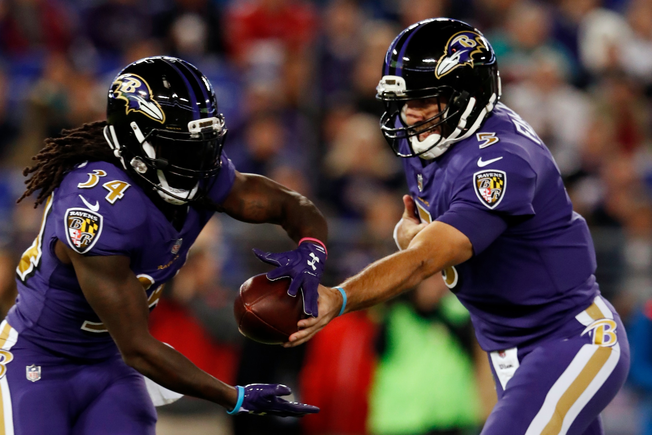 BALTIMORE, MD - OCTOBER 26: Quarterback Joe Flacco #5 hands the ball of to running back Alex Collins #34 of the Baltimore Ravens in the first quarter against the Miami Dolphins at M&T Bank Stadium on October 26, 2017 in Baltimore, Maryland. (Photo by Todd