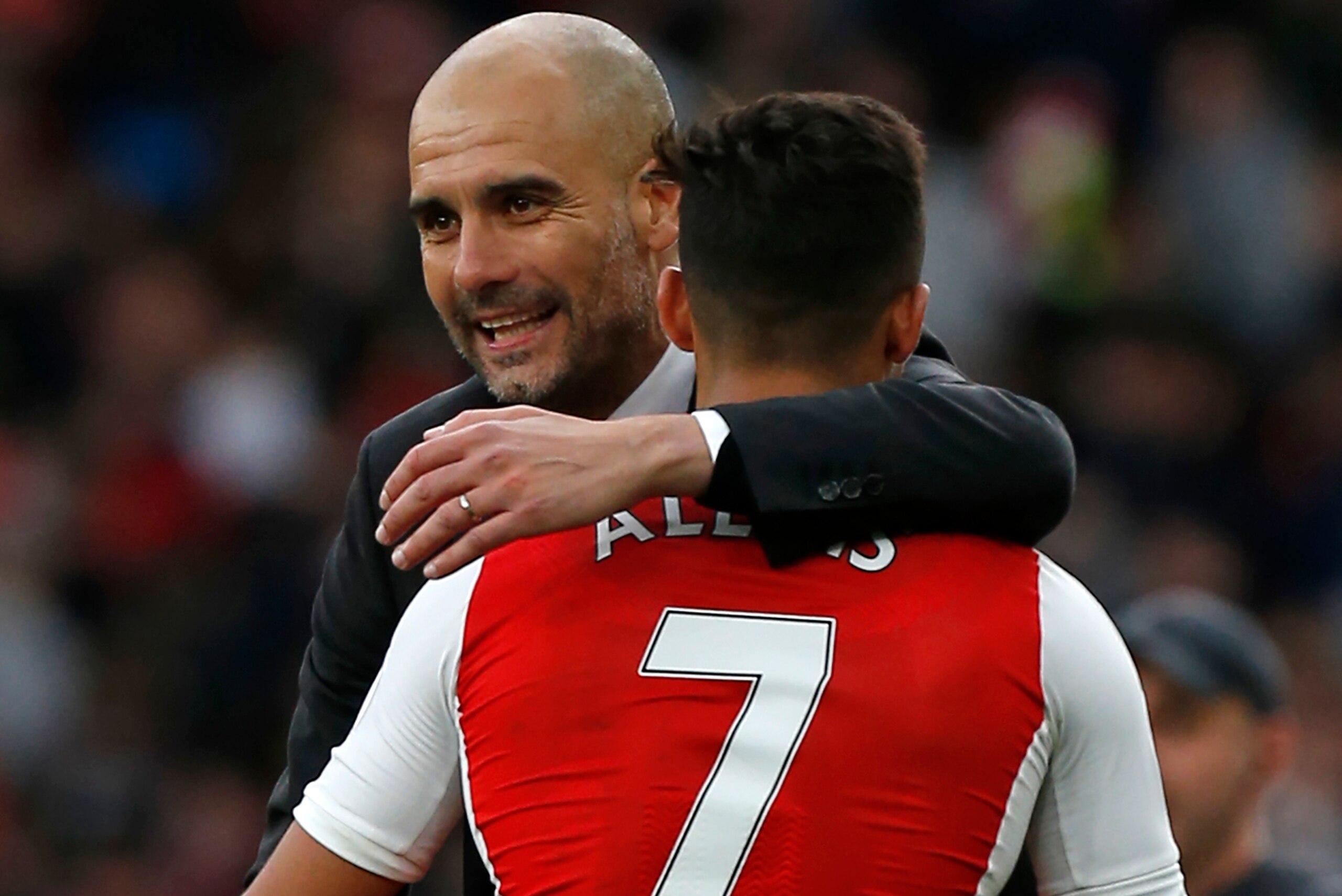 Manchester City's Spanish manager Pep Guardiola embraces Arsenal's Chilean striker Alexis Sanchez on the pitch after the English Premier League football match between Arsenal and Manchester City at The Emirates in London, on April 2, 2017.
The game finish