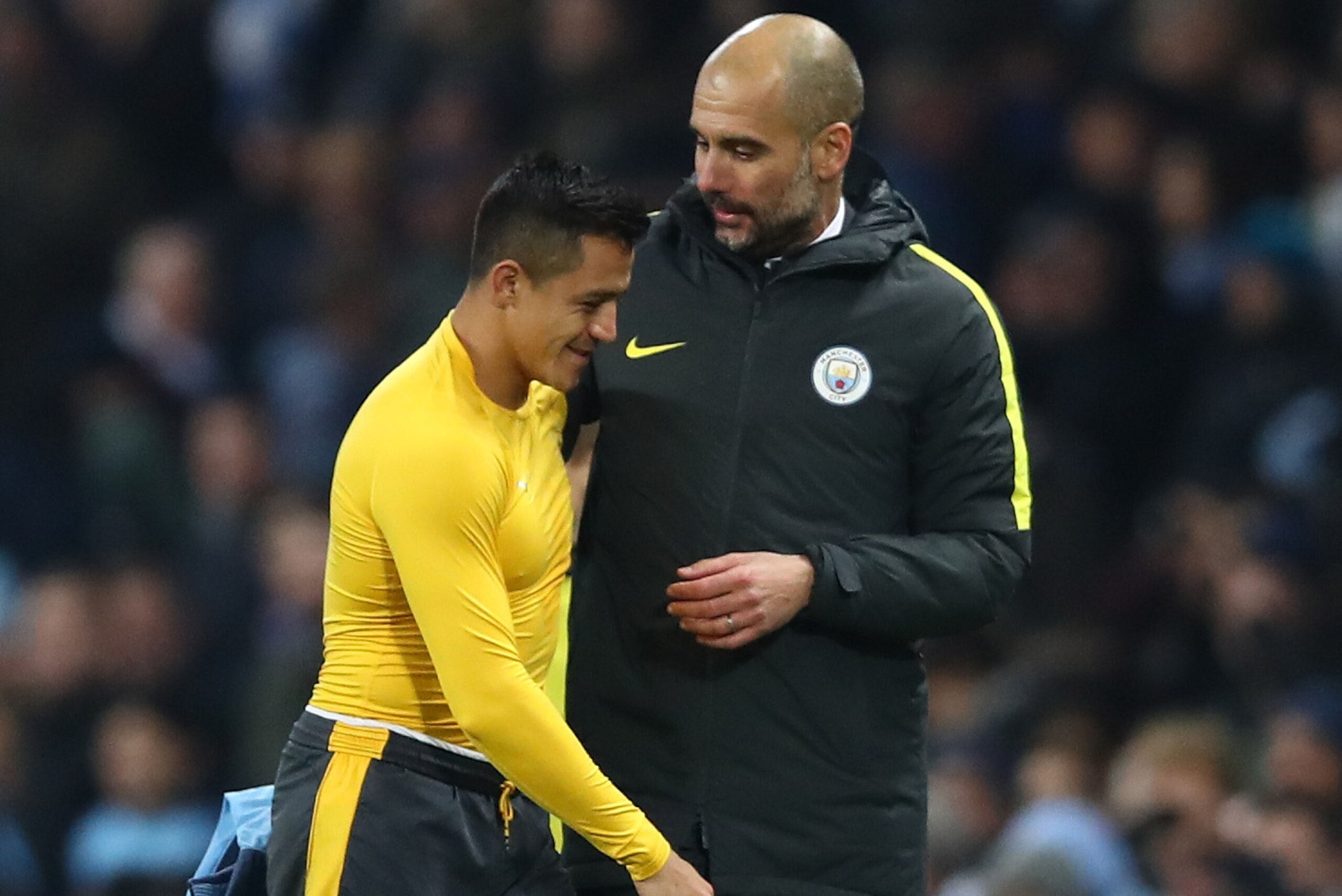 MANCHESTER, ENGLAND - DECEMBER 18:  Alexis Sanchez of Arsenal (L) and Josep Guardiola, Manager of Manchester City (R) embrace after the final whistle during the Premier League match between Manchester City and Arsenal at the Etihad Stadium on December 18,
