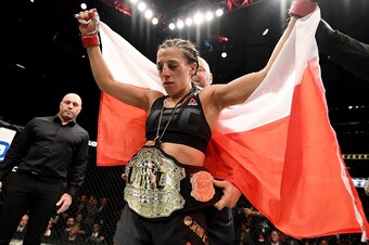 NEW YORK, NY - NOVEMBER 12:  Joanna Jedrzejczyk of Poland is awarded the belt after her unanimous decision victory in their women's strawweight championship bout against Karolina Kowalkiewicz of Poland during the UFC 205 event at Madison Square Garden on 