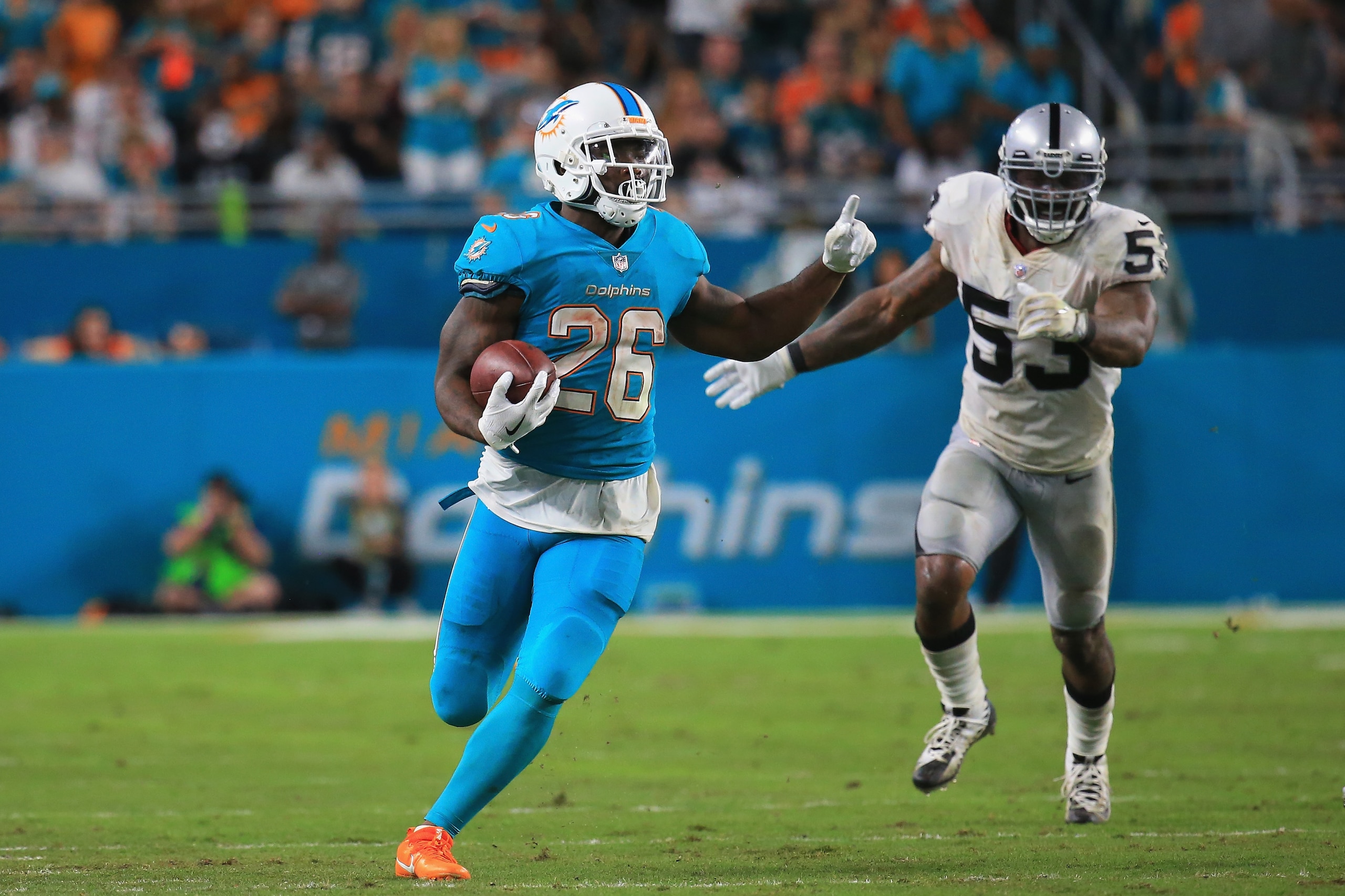 MIAMI GARDENS, FL - NOVEMBER 05: Running back Damien Williams #26 of the Miami Dolphins is challenged by middle linebacker NaVorro Bowman #53 of the Oakland Raiders at Hard Rock Stadium on November 5, 2017 in Miami Gardens, Florida.  (Photo by Chris Trotm