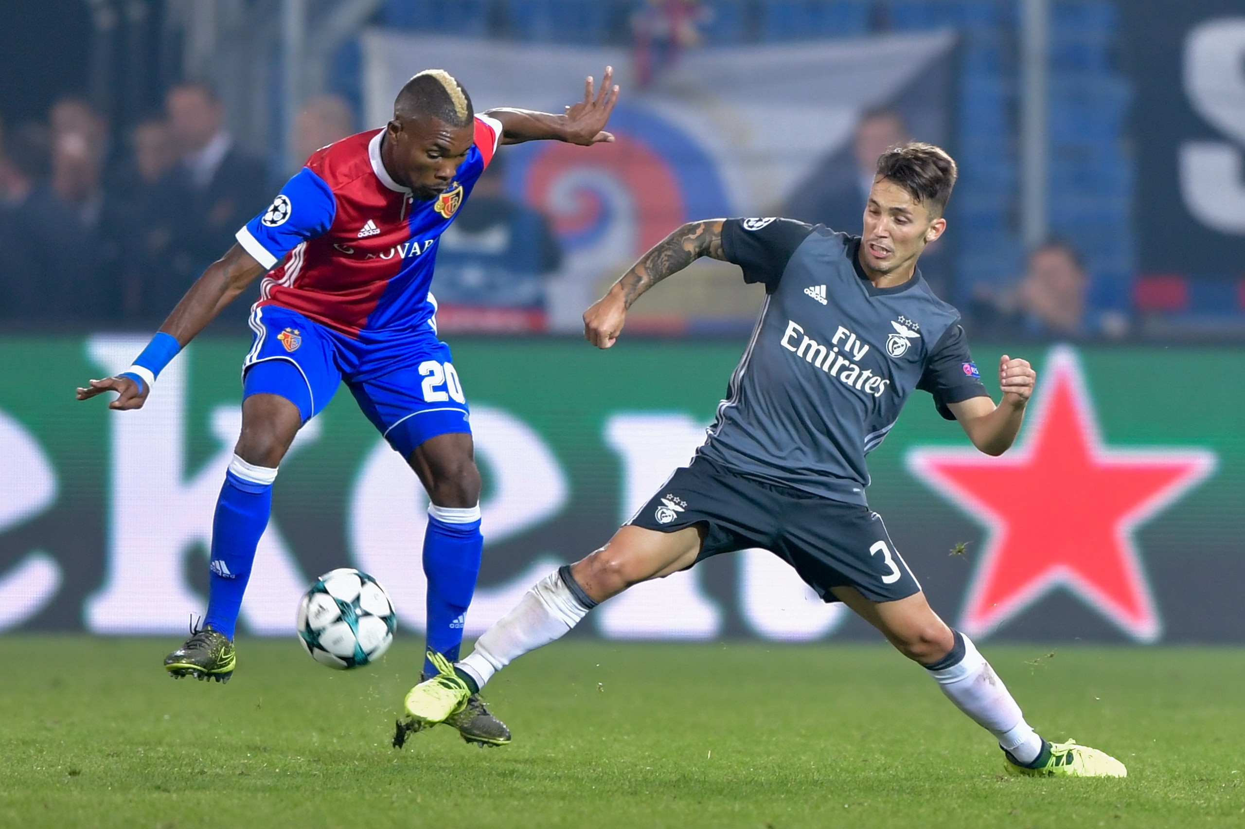Basel's Ivorian midfielder Geoffroy Serey Die (L) and Benfica's Spanish defender Alejandro Grimaldo fight for the ball during the UEFA Champions League Group A football match between FC Basel 1893 and Benfica at St. Jakob-Park Stadium in Basel on Septembe