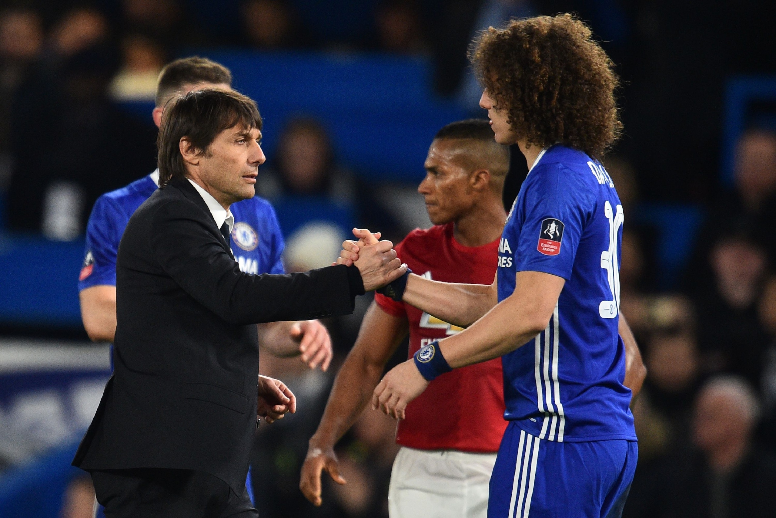 Chelsea's Italian head coach Antonio Conte (L) shakes hands with Chelsea's Brazilian defender David Luiz on the pitch after the English FA Cup quarter final football match between Chelsea and Manchester United at Stamford Bridge in London on March 13, 201