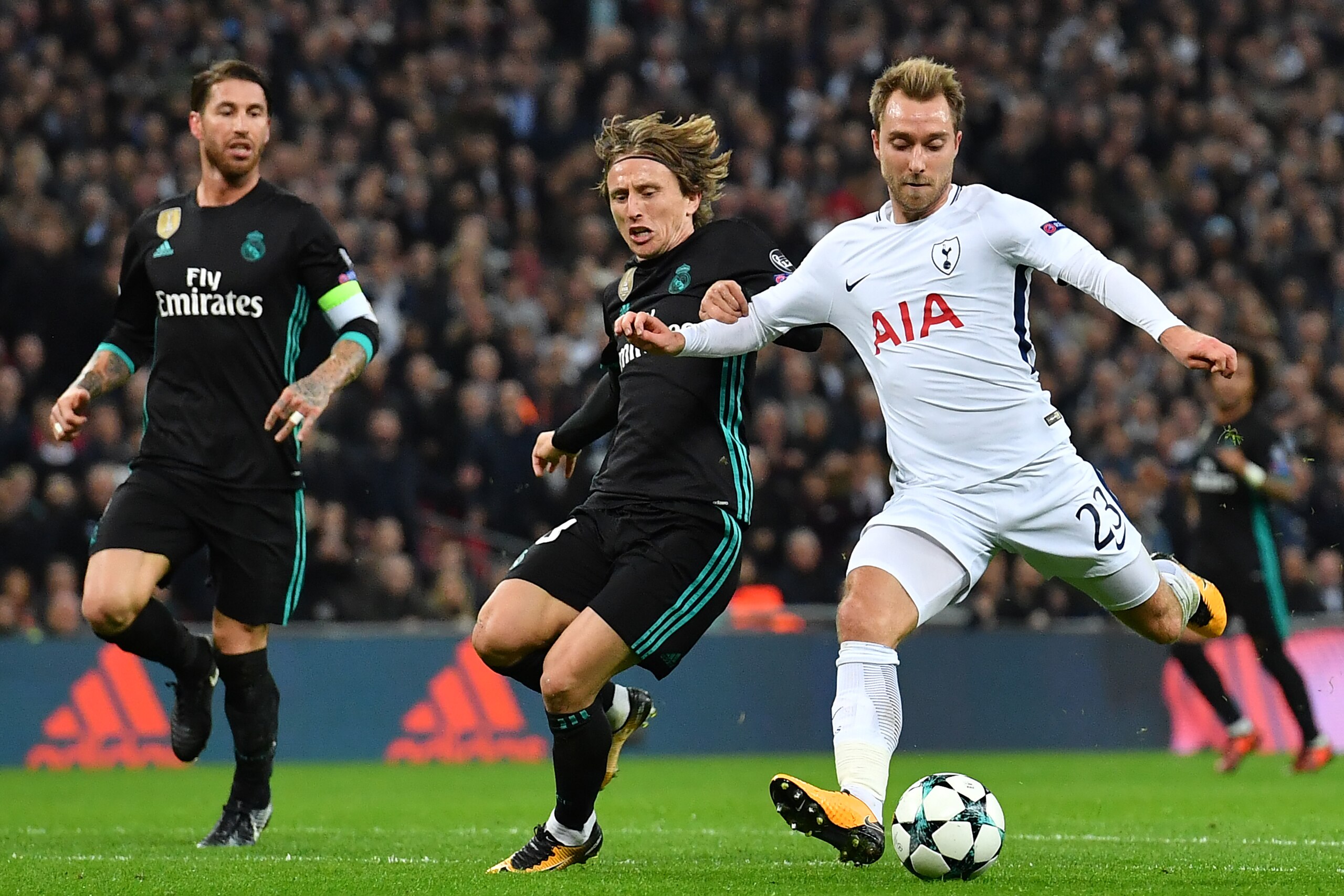 Tottenham Hotspur's Danish midfielder Christian Eriksen (R) shoots past Real Madrid's Croatian midfielder Luka Modric (C) to score their third goal during the UEFA Champions League Group H football match between Tottenham Hotspur and Real Madrid at Wemble