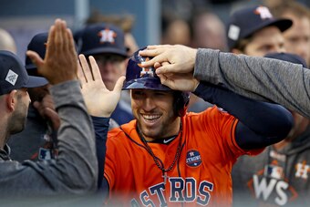 LOS ANGELES, CA - NOVEMBER 01:  George Springer #4 of the Houston Astros celebrates with his teammates in the dugout after scoring off of a single hit by Alex Bregman #2 iin the first inning and reaches second safely on a throwing error against the Los An