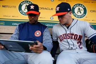 OAKLAND, CA - APRIL 14: Bench Coach Alex Cora #26 and Alex Bregman #2 of the Houston Astros work in the dugout prior to the game against the Oakland Athletics at the Oakland Alameda Coliseum on April 14, 2017 in Oakland, California. The Astros defeated th