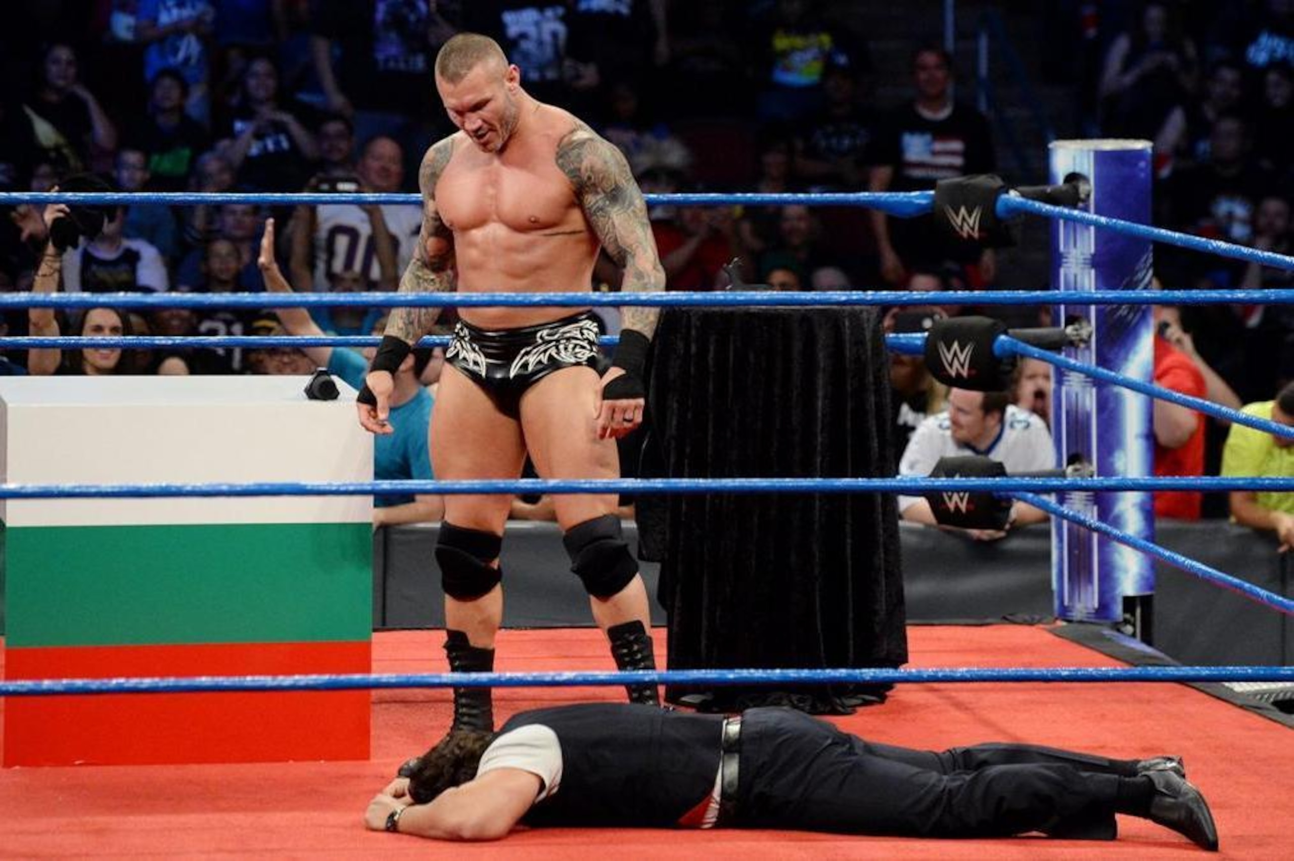 Randy Orton towers over a fallen Rusev.