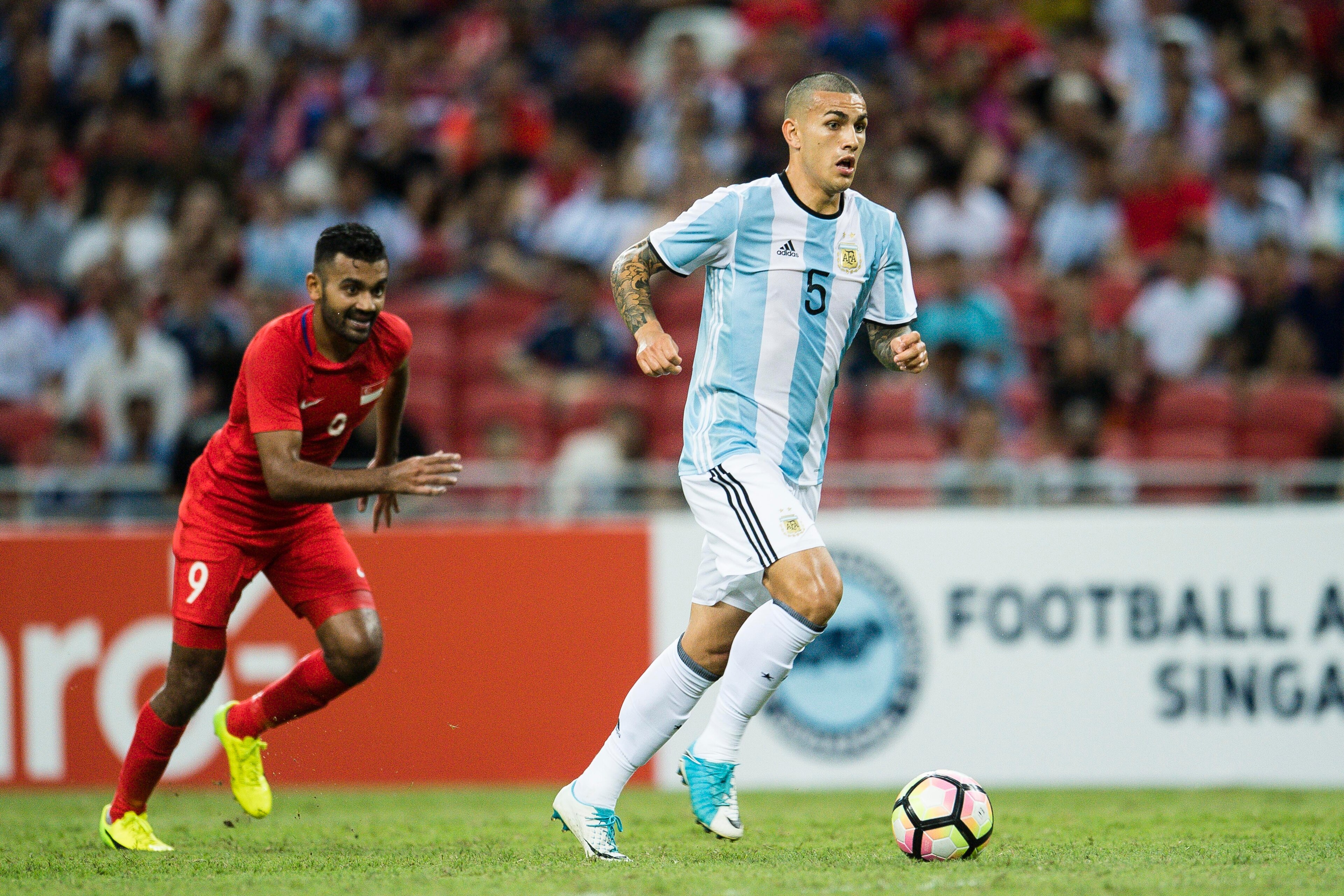 SINGAPORE, SINGAPORE - JUNE 13: Leandro Paredes of Argentina (R) in action against Faritz Hameed of Singapore (L) during the International Test match between Argentina and Singapore at National Stadium on June 13, 2017 in Singapore. (Photo by Power Sport 