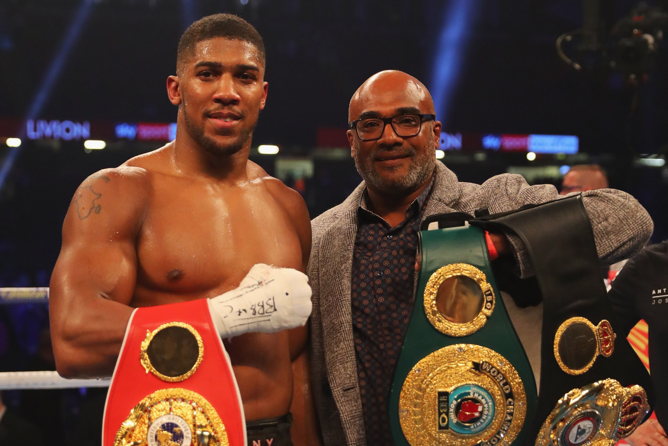 CARDIFF, WALES - OCTOBER 28:  Anthony Joshua and his father Robert Joshua celebrate victory with his belts after a 10th round stoppage during the IBF, WBA & IBO Heavyweight Championship contest against Carlos Takam at Principality Stadium on October 28, 2