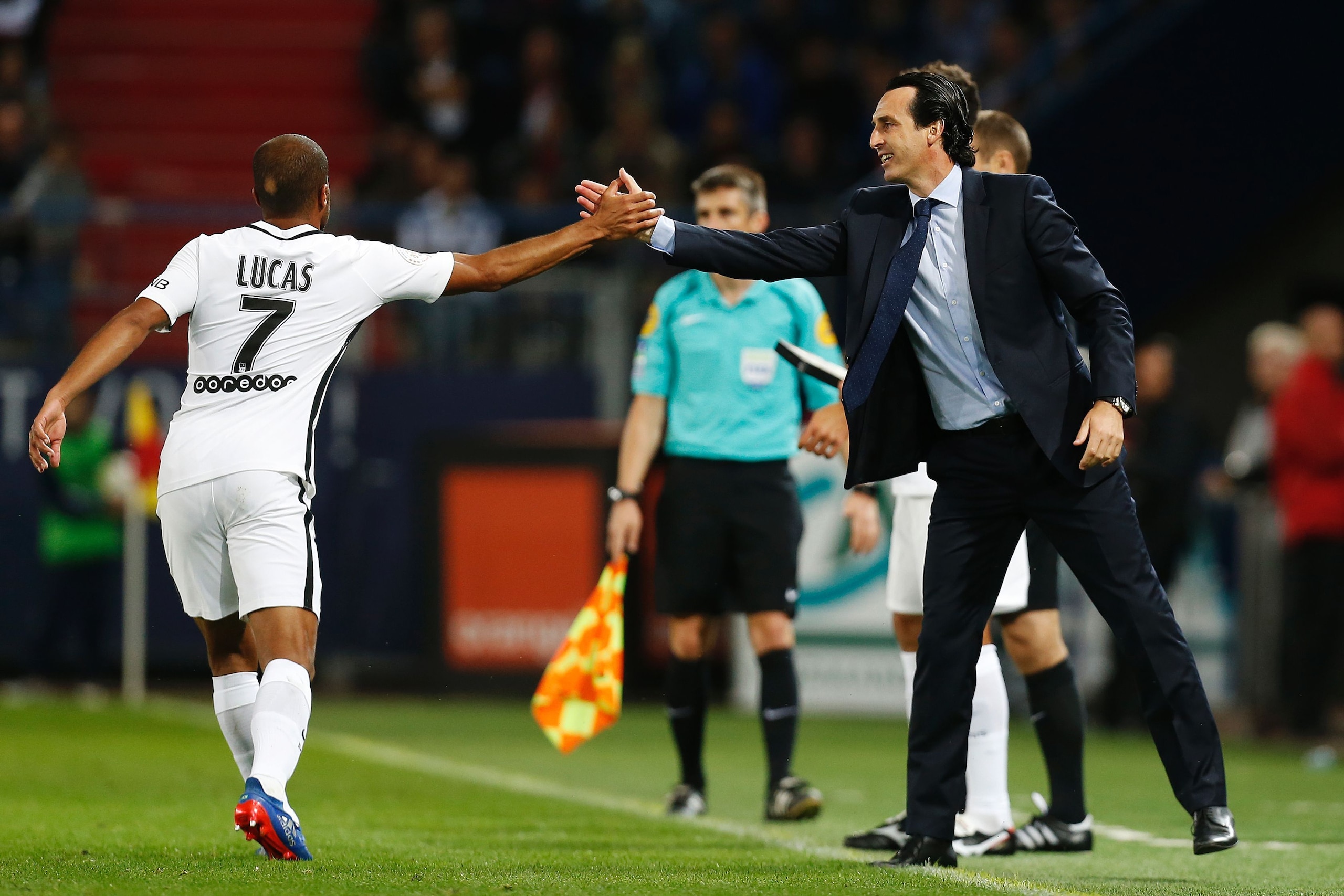 TOPSHOT - Paris Saint-Germain's Brazilian midfielder Lucas Moura (L)  celebrates with PSG's Spanish head coach Unai Emery after scoring during the French L1 football match between Caen (SMC) and Paris Saint-Germain (PSG) on September 16, 2016, at the Mich