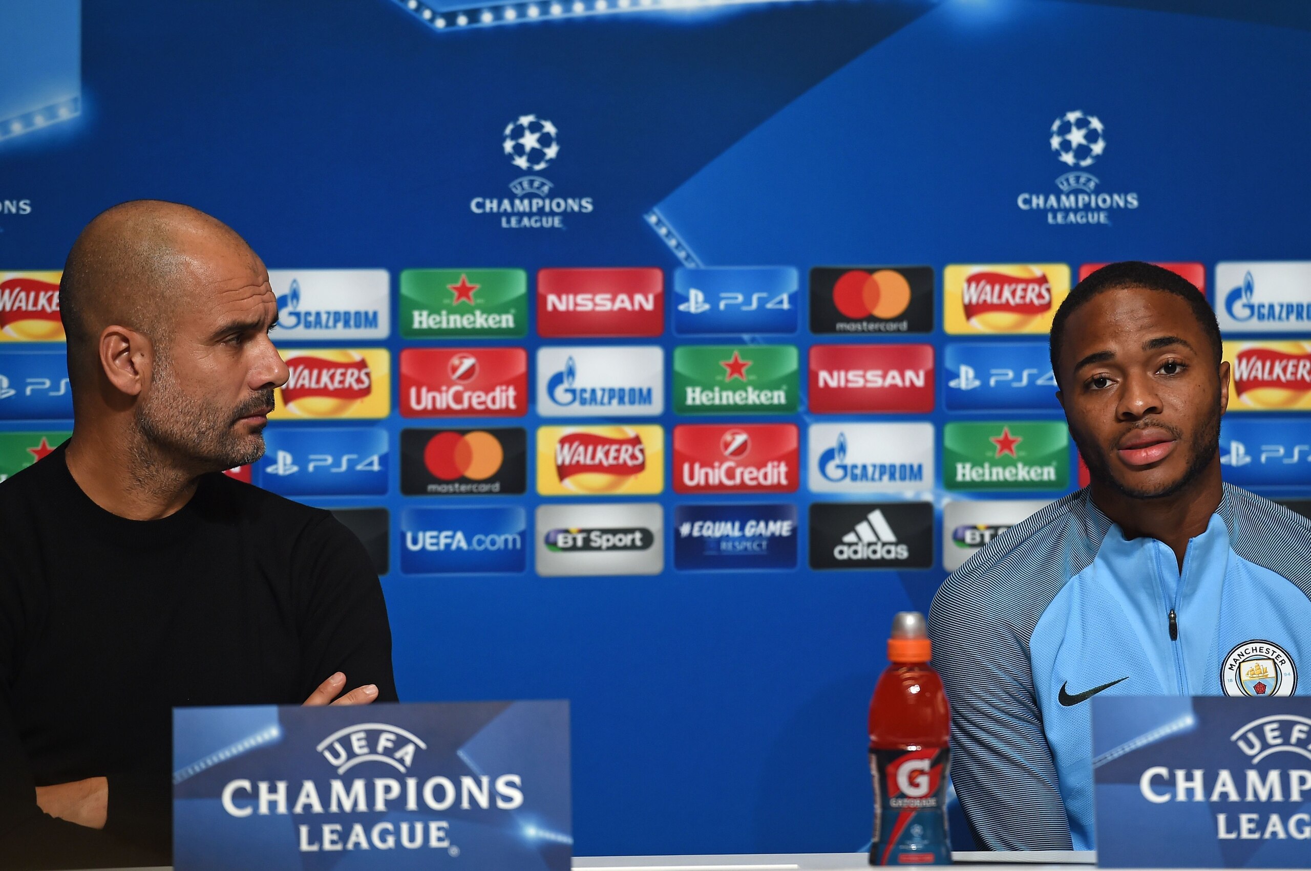 Manchester City's Spanish manager Pep Guardiola (L) watches as Manchester City's English midfielder Raheem Sterling (R) speaks at a press conference in Manchester, north west England on October 16, 2017, on the eve of their UEFA Champions League Group F m