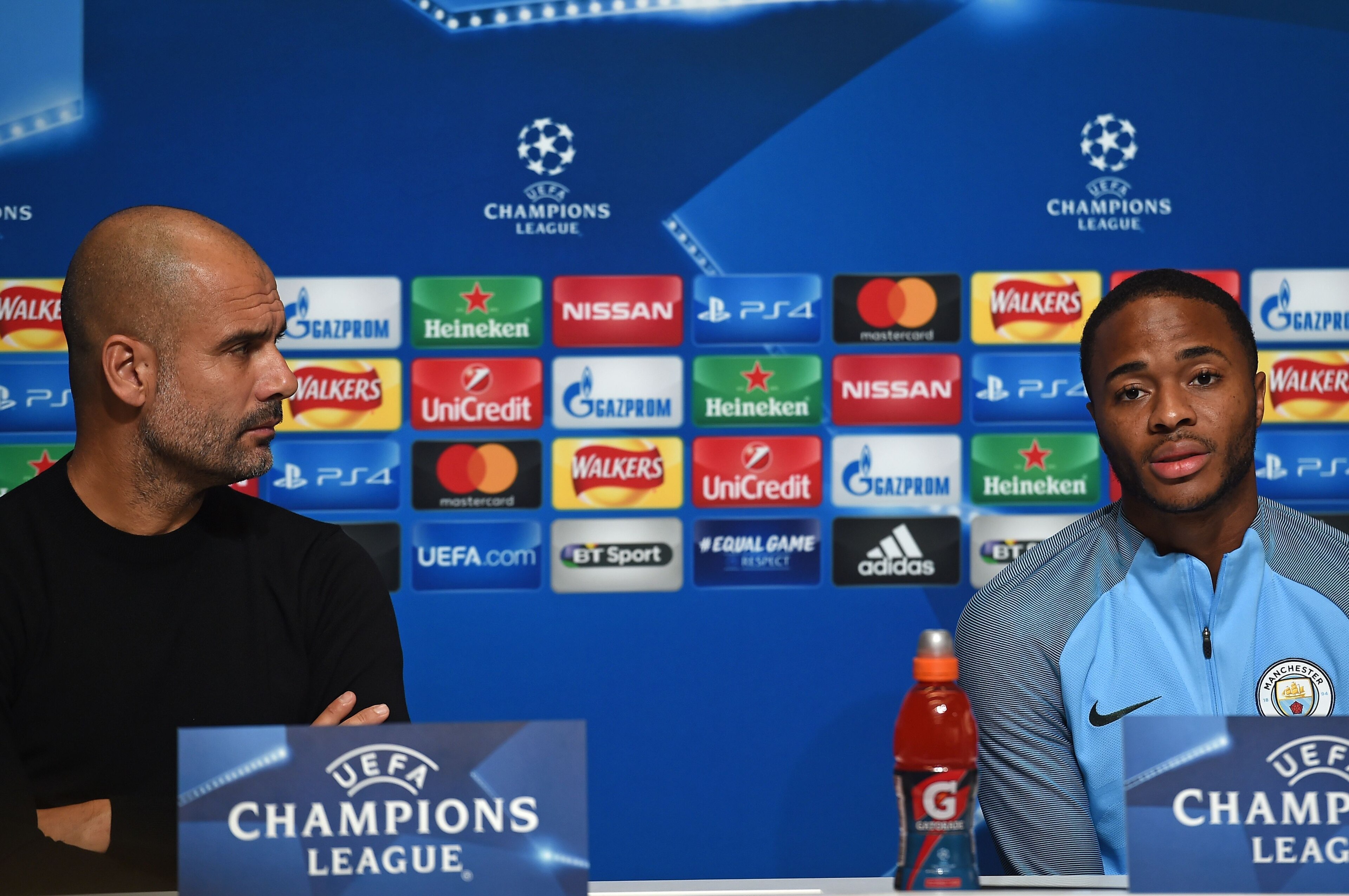 Manchester City's Spanish manager Pep Guardiola (L) watches as Manchester City's English midfielder Raheem Sterling (R) speaks at a press conference in Manchester, north west England on October 16, 2017, on the eve of their UEFA Champions League Group F m
