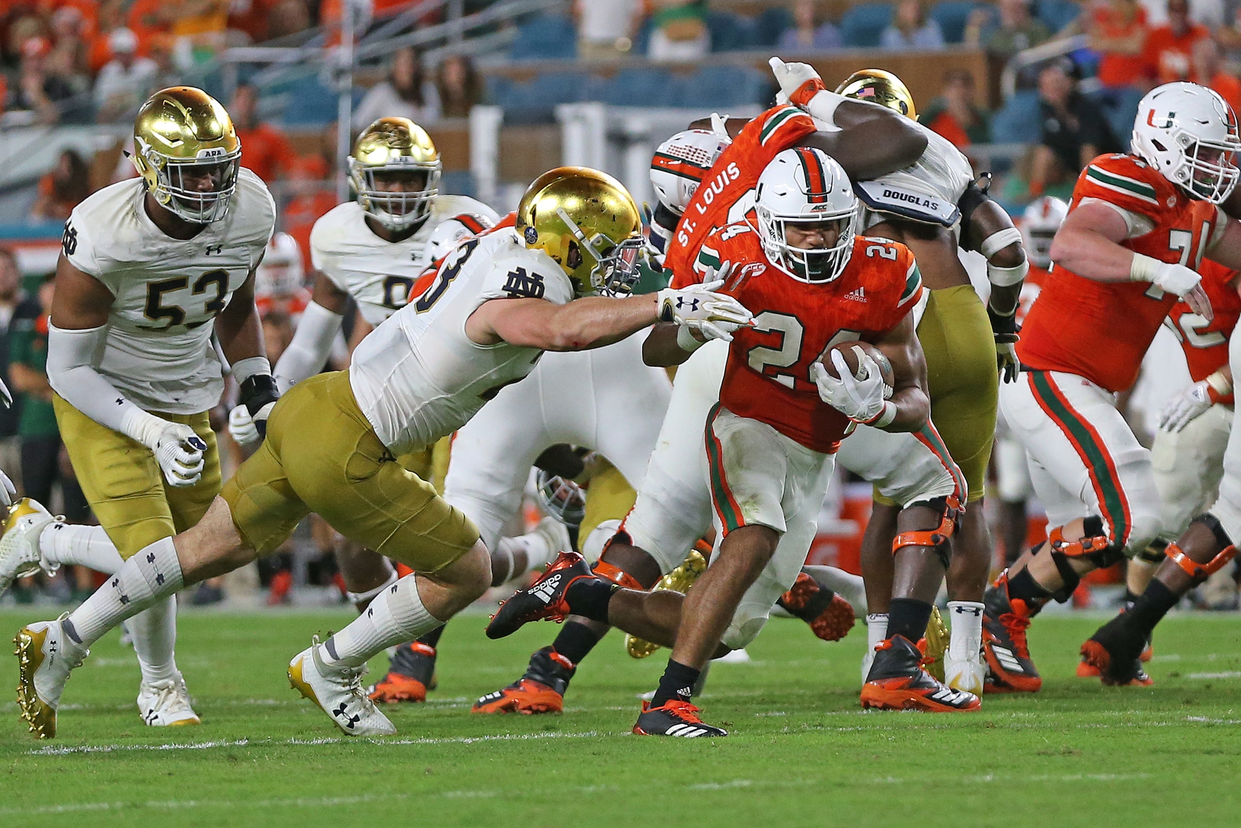 MIAMI GARDENS, FL - NOVEMBER 11: Travis Homer #24 of the Miami Hurricanes runs with the ball past Drue Tranquill #23 of the Notre Dame Fighting Irish on November 11, 2017 at Hard Rock Stadium in Miami Gardens, Florida. Miami defeated Notre Dame 41-8. (Pho