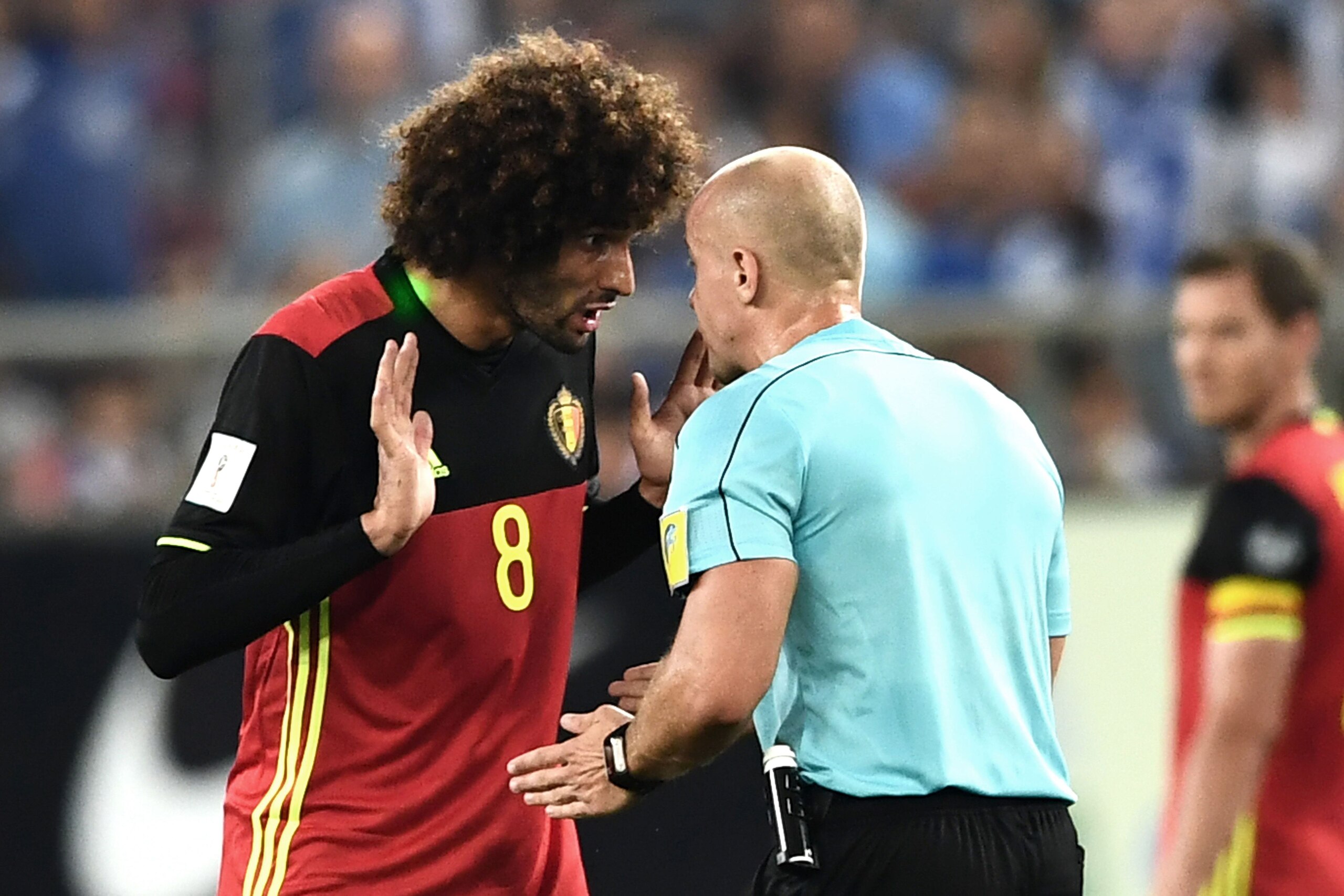 Belgium's Marouane Fellaini (L) gestures as he complains to Polish referee Szymon Marciniak during their Group H 2018 FIFA World Cup qualifying football match between Greece and Belgium at The Georgios Karaiskakis Stadium in Piraeus near Athens on Septemb