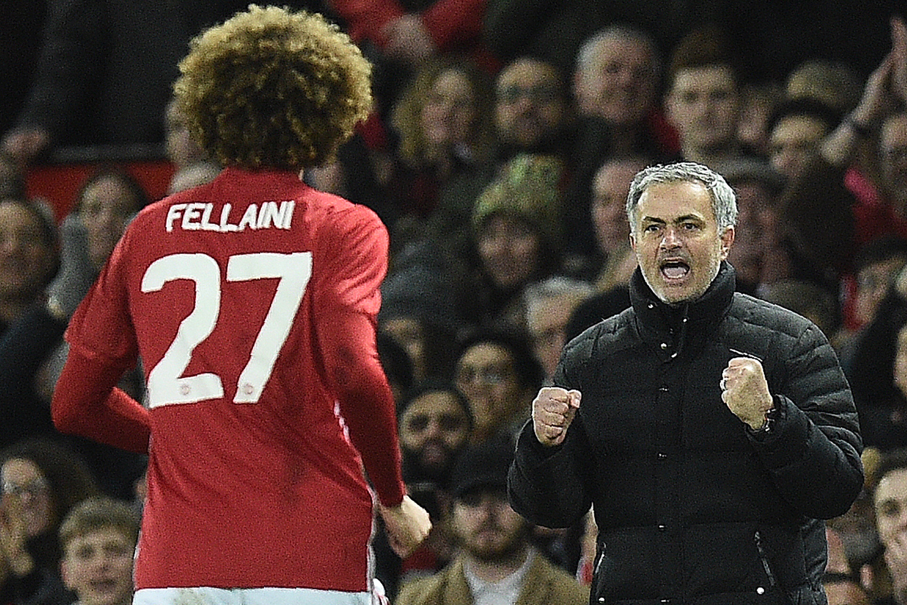 Manchester United's Belgian midfielder Marouane Fellaini (L) celebrates scoring his team's second goal with Manchester United's Portuguese manager Jose Mourinho during the EFL (English Football League) Cup semi-final football match between Manchester Unit