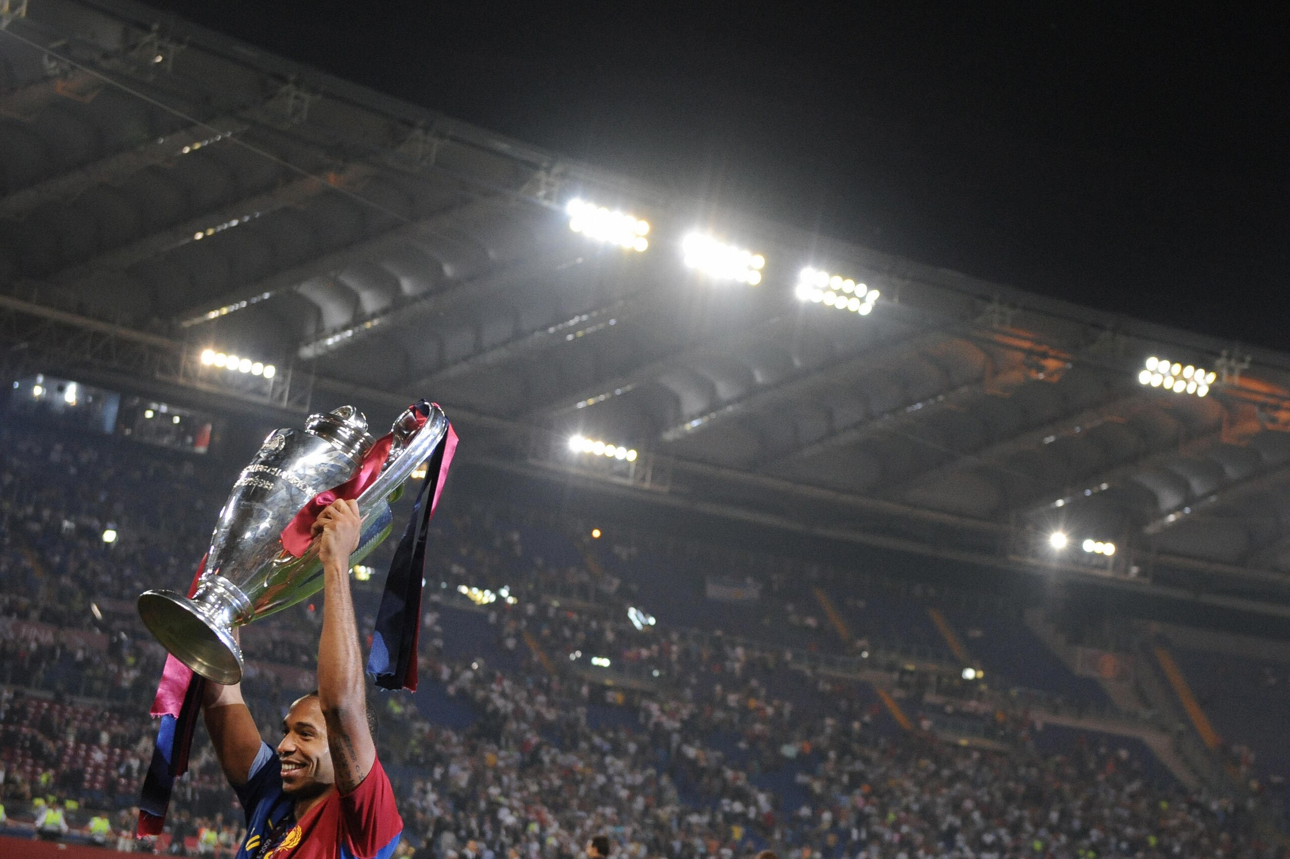 Barcelona´s French forward Thierry Henry celebrates with the Champions League Cup after the trophy ceremony on May 27, 2009 at the Olympic Stadium in Rome. Barcelona defeated  Manchester United 2-0 in the final of the UEFA football Champions League.      