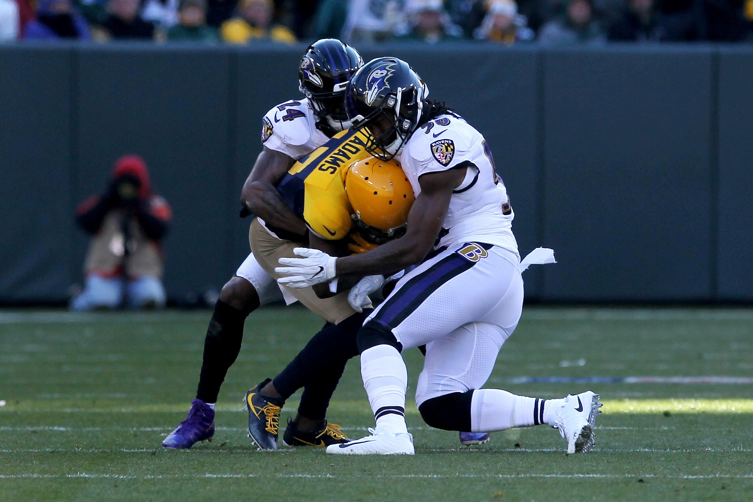 GREEN BAY, WI - NOVEMBER 19:  Brandon Carr #24 and Tim Williams #56 of the Baltimore Ravens combine for a tackle against Davante Adams #17 of the Green Bay Packers in the second quarter at Lambeau Field on November 19, 2017 in Green Bay, Wisconsin. (Photo
