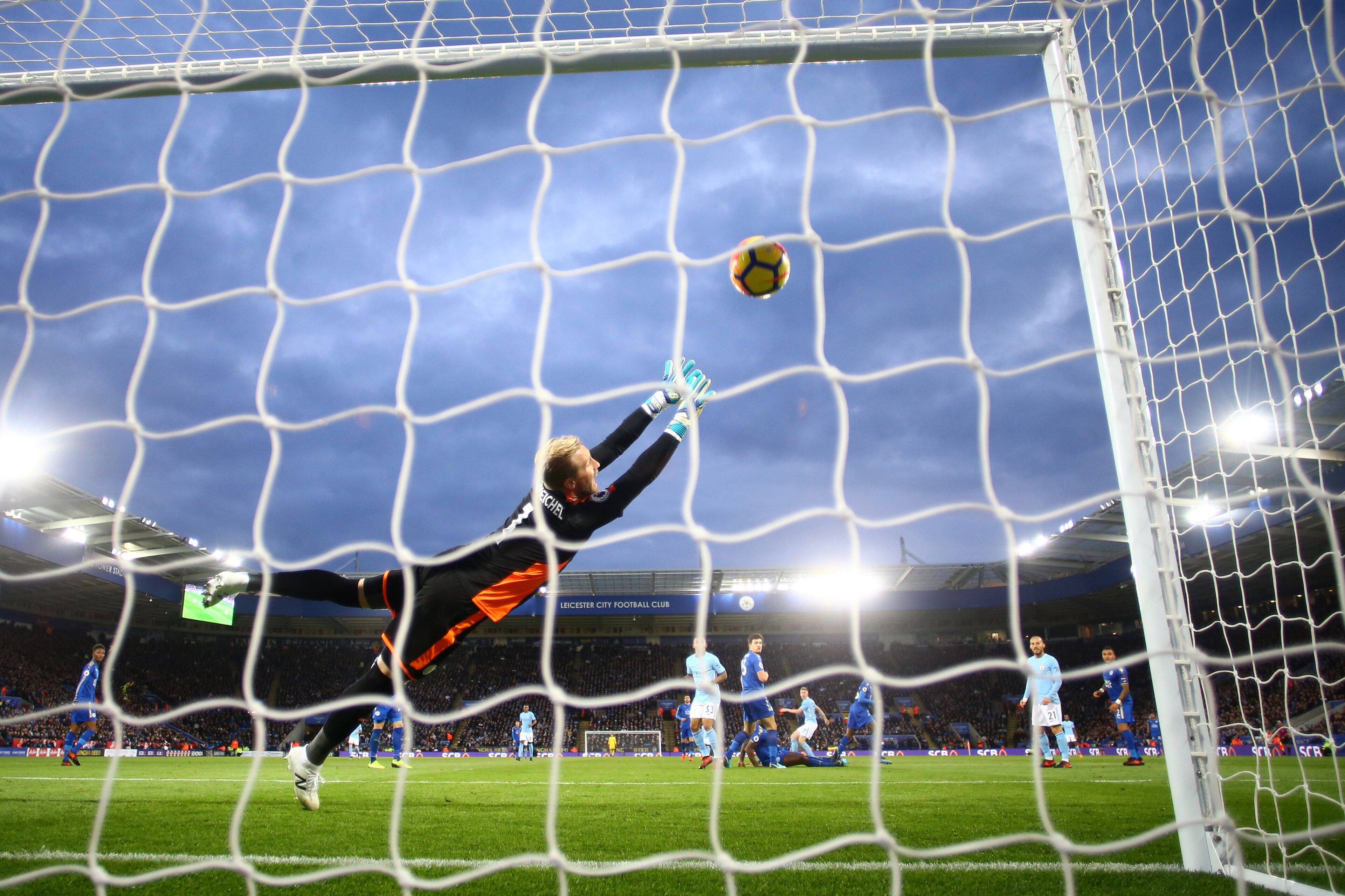 LEICESTER, ENGLAND - NOVEMBER 18: Kasper Schmeichel of Leicester City dives in vain as Kevin De Bruyne of Manchester City scores his side's second goal during the Premier League match between Leicester City and Manchester City at The King Power Stadium on