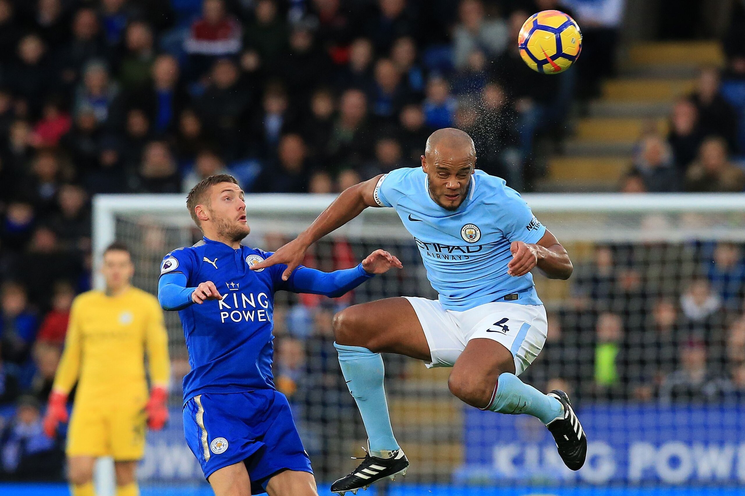 Manchester City's Belgian defender Vincent Kompany (R) heads the ball to clear it from the path of Leicester City's English striker Jamie Vardy during the English Premier League football match between Leicester City and Manchester City at King Power Stadi