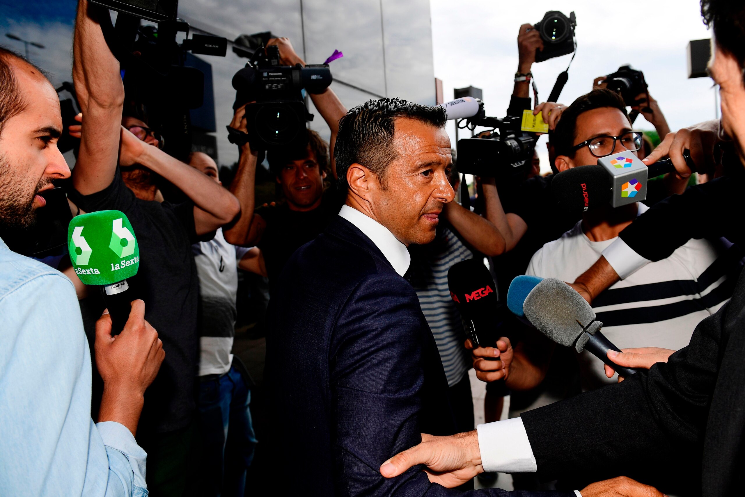 Footballing super-agent Jorge Mendes (C), surrounded by journalists, arrives at the Court in Pozuelo de Alarcon on June 27, 2017 to be questioned by Spanish judge as part of a probe into Colombian striker Radamel Falcao's alleged tax evasion. / AFP PHOTO 