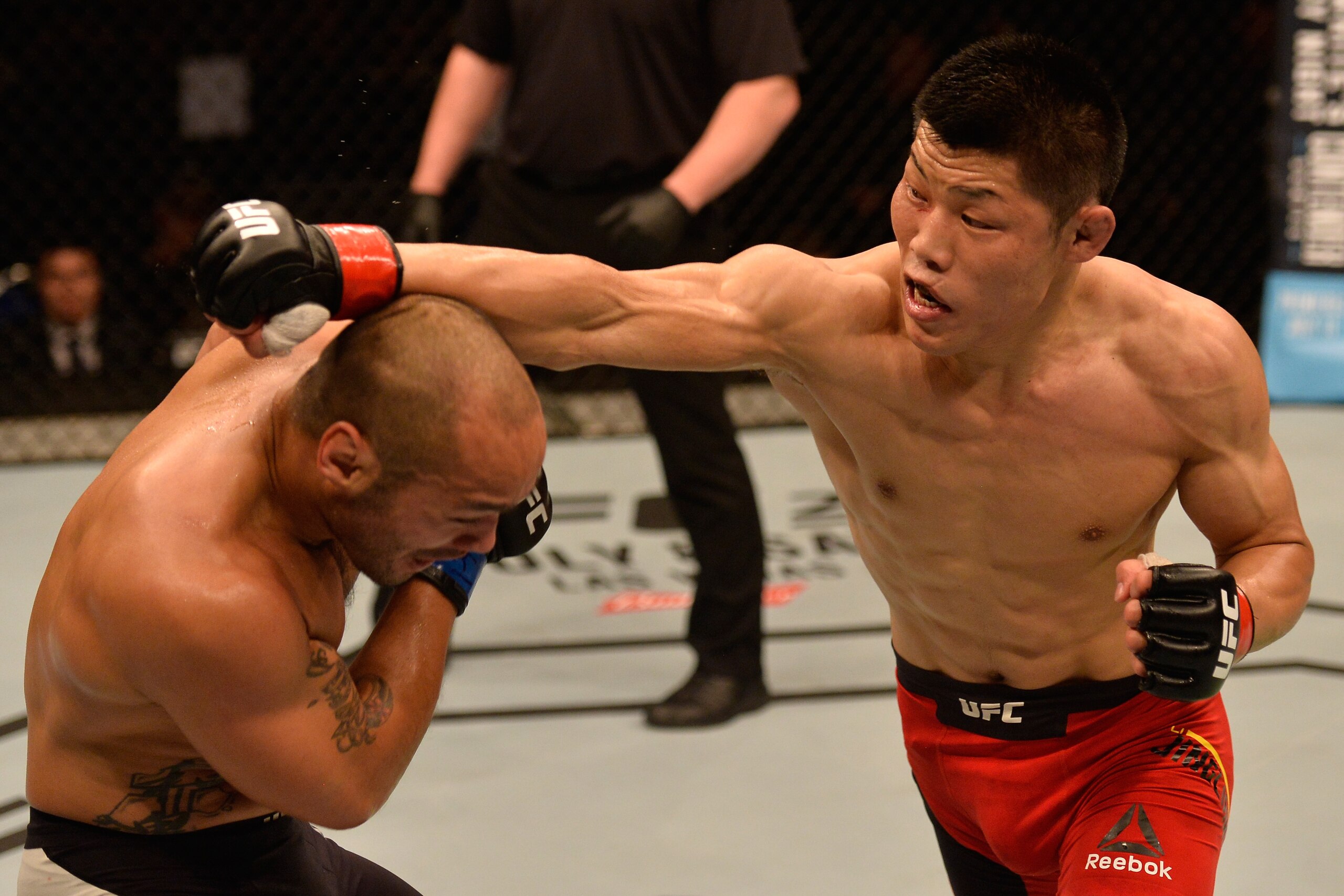 SINGAPORE - JUNE 17:   (R-L) Li Jingliang of China punches Frank Camacho of the Northern Mariana Islands in their welterweight bout during the UFC Fight Night event at the Singapore Indoor Stadium on June 17, 2017 in Singapore. (Photo by Brandon Magnus/Zu