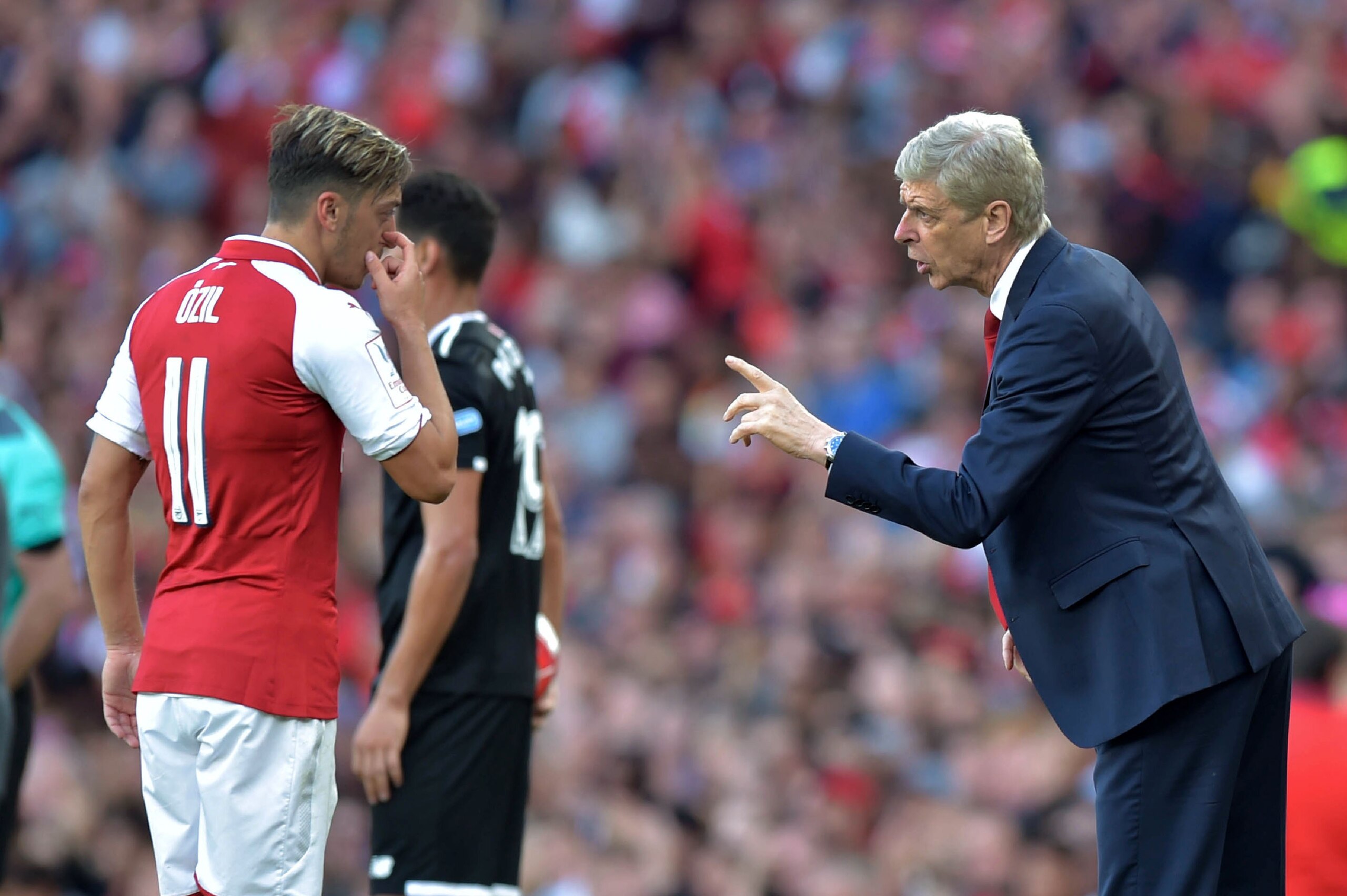 Arsenal's French manager Arsene Wenger (R) interacts with Arsenal's German midfielder Mesut Ozil during the pre-season friendly football match between Arsenal and Sevilla at The Emirates Stadium in north London on July 30, 2017, the game is one of four ma