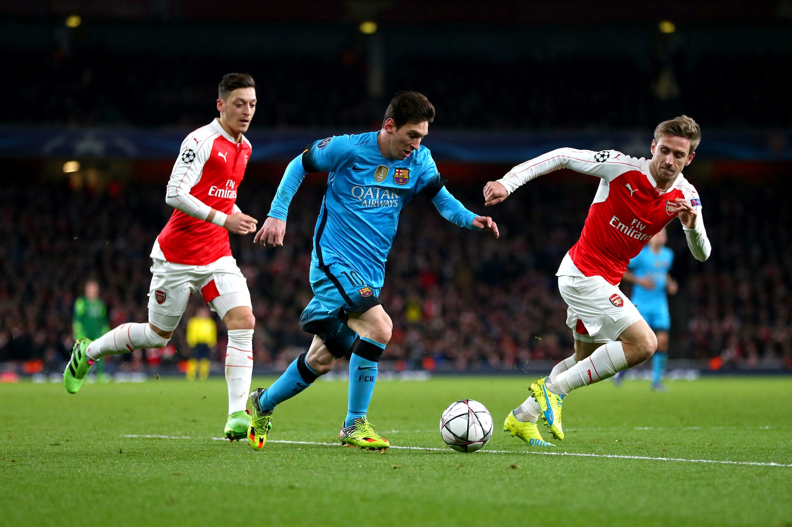 LONDON, ENGLAND - FEBRUARY 23 :  Lionel Messi of FC Barcelona  tries to get past Mesut Ozil and Nacho Monreal of Arsenal during the UEFA Champions League match between Arsenal and Barcelona at the Emirates Stadium on February 23, 2016 in London, United Ki