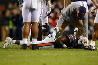 AUBURN, AL - NOVEMBER 25:  Kerryon Johnson #21 of the Auburn Tigers receives treatment from a trainer after suffering an injury during the fourth quarter against the Alabama Crimson Tide at Jordan Hare Stadium on November 25, 2017 in Auburn, Alabama.  (Ph