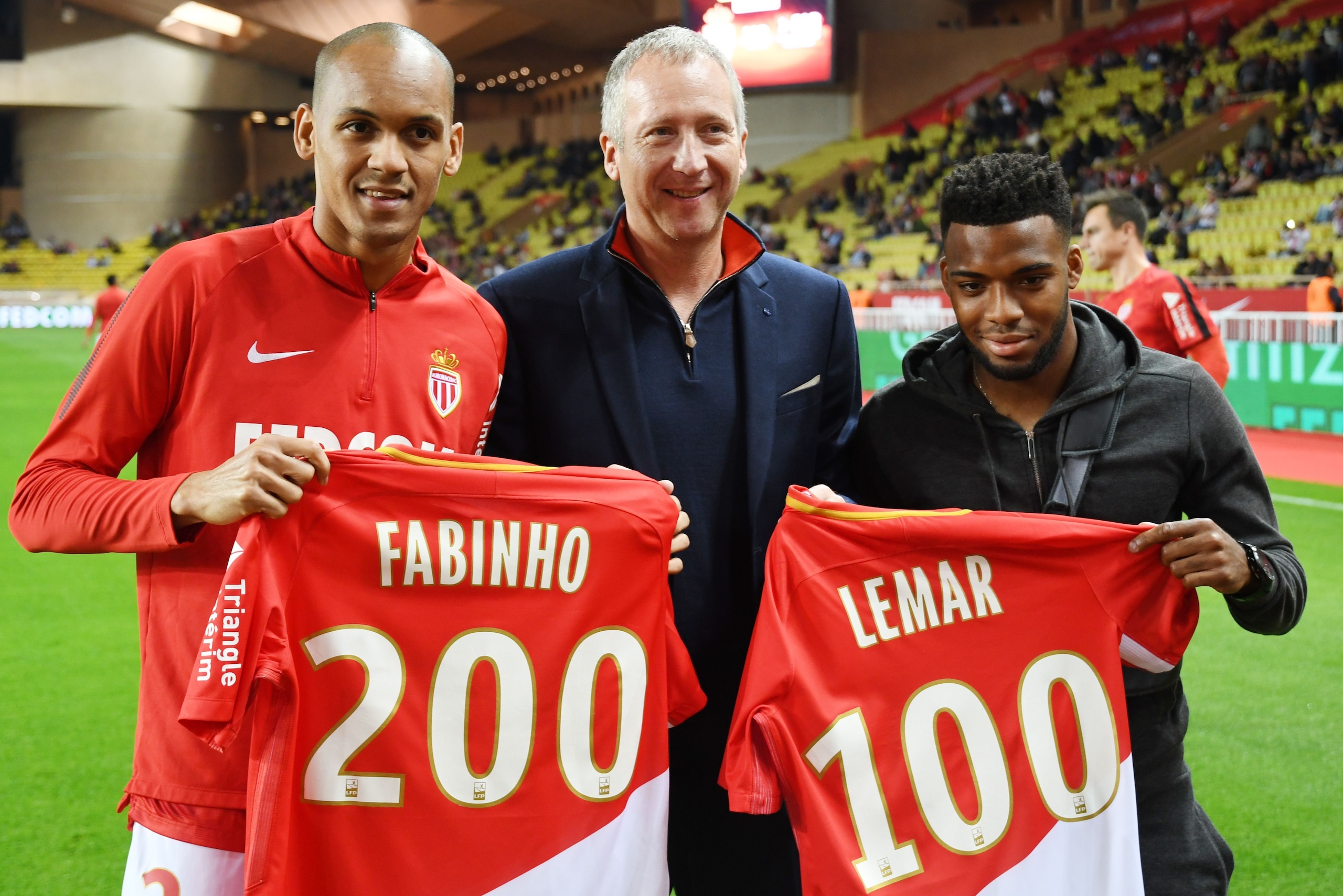 (L-R) Monaco's Brazilian defender Fabinho, Monaco's Russian Vice club President Vadim Vasilyev, Monaco's French midfielder Thomas Lemar pose vith jersey celebrating their 200th and 100th matches played on L1 before the French L1 football match Monaco (ASM