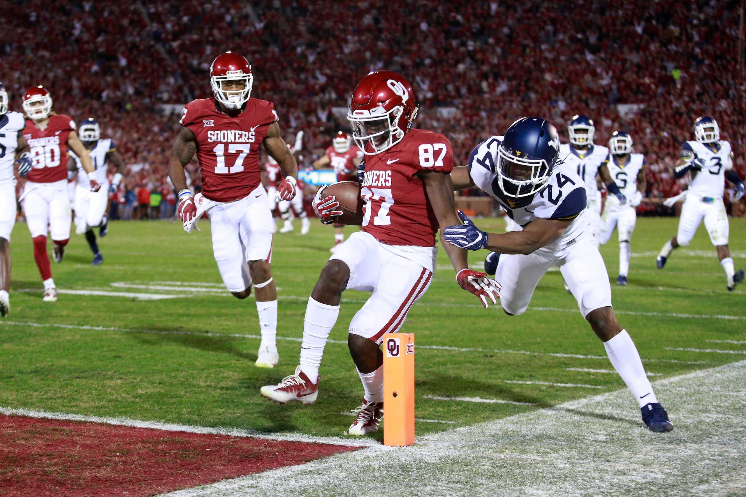 NORMAN, OK - NOVEMBER 25: Wide receiver Myles Tease #87 of the Oklahoma Sooners scores as cornerback Hakeem Bailey #24 of the West Virginia Mountaineers defends at Gaylord Family Oklahoma Memorial Stadium on November 25, 2017 in Norman, Oklahoma. Oklahoma