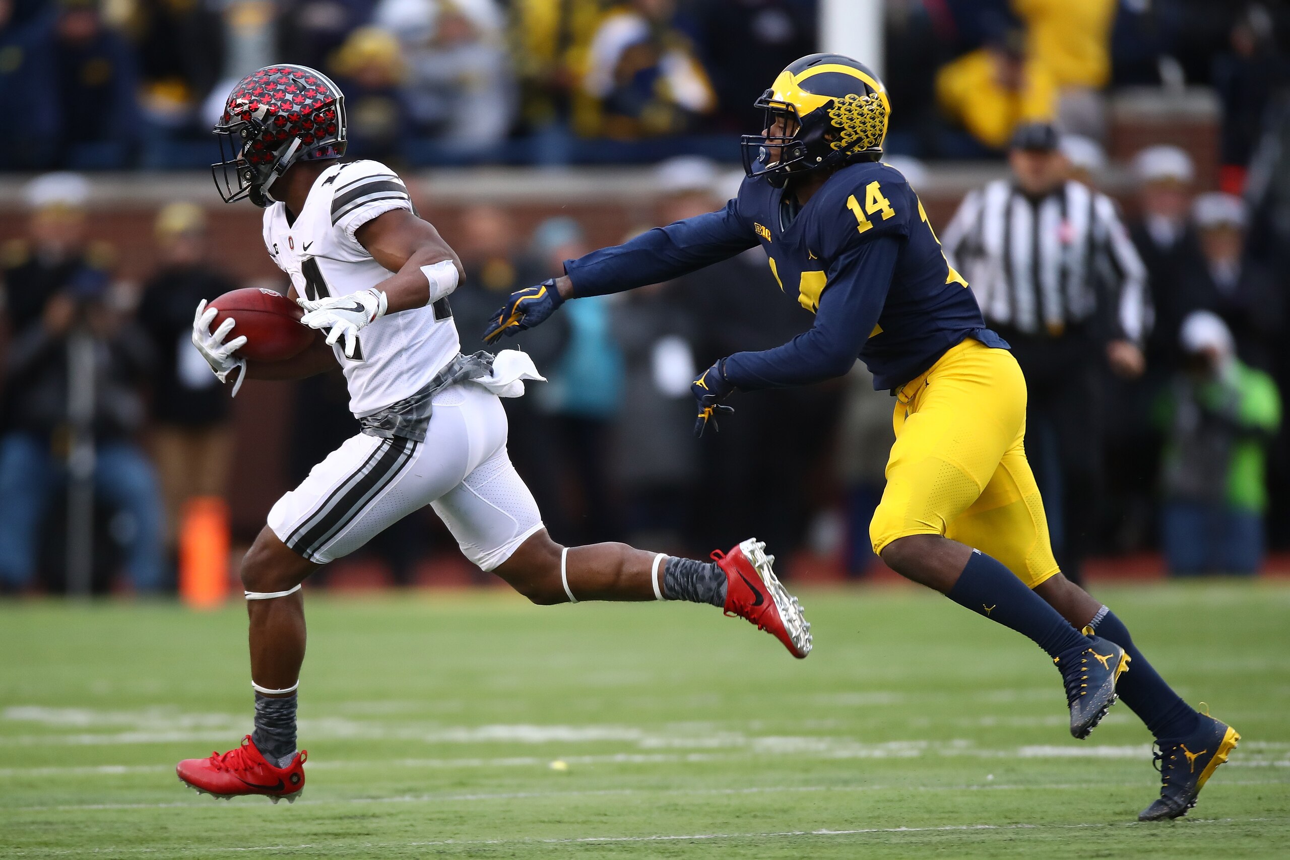 ANN ARBOR, MI - NOVEMBER 25:  K.J. Hill #14 of the Ohio State Buckeyes is chased down by Josh Metellus #14 of the Michigan Wolverines in the second half on November 25, 2017 at Michigan Stadium in Ann Arbor, Michigan. (Photo by Gregory Shamus/Getty Images
