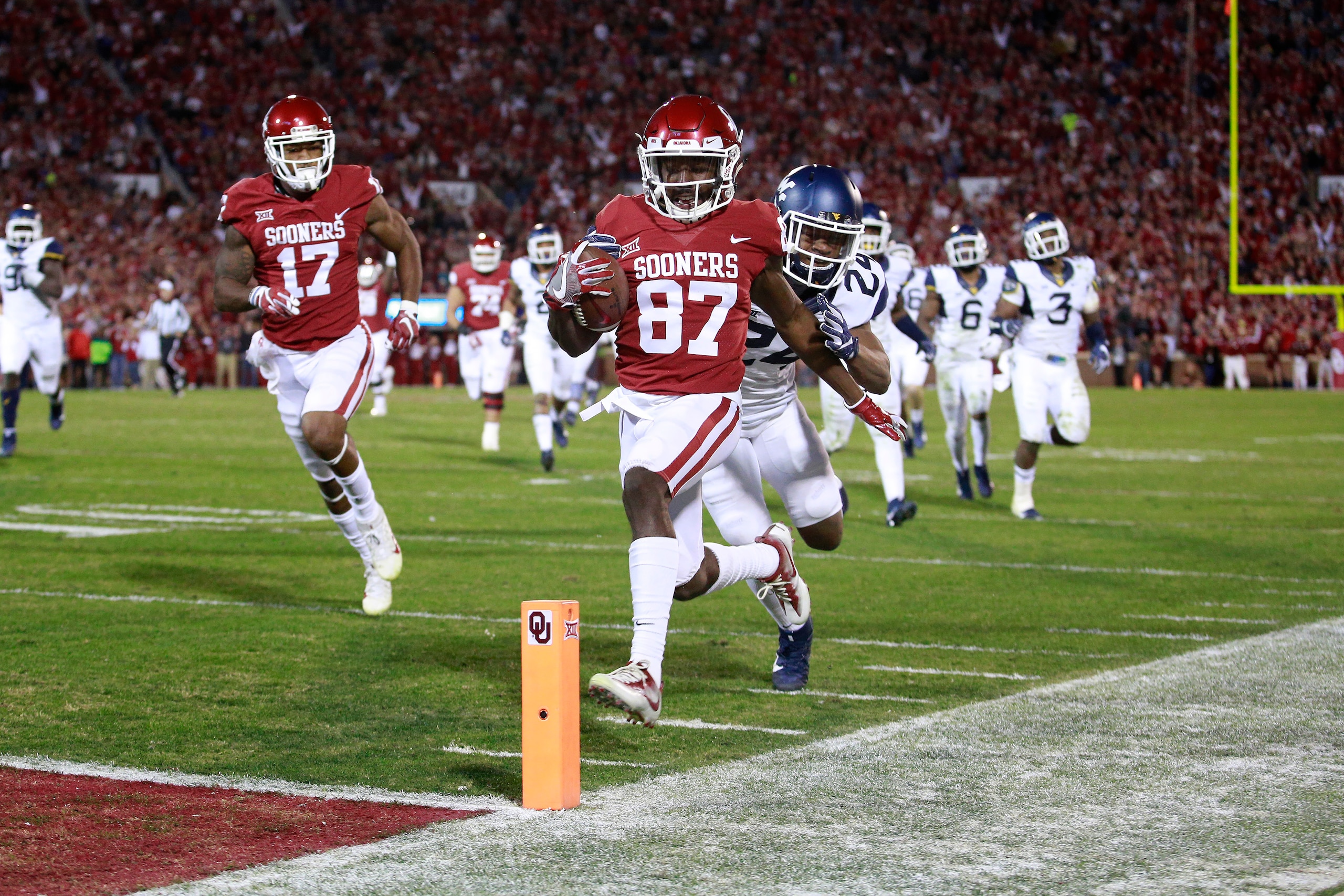 NORMAN, OK - NOVEMBER 25: Wide receiver Myles Tease #87 of the Oklahoma Sooners looks to score as cornerback Hakeem Bailey #24 of the West Virginia Mountaineers defends at Gaylord Family Oklahoma Memorial Stadium on November 25, 2017 in Norman, Oklahoma. 