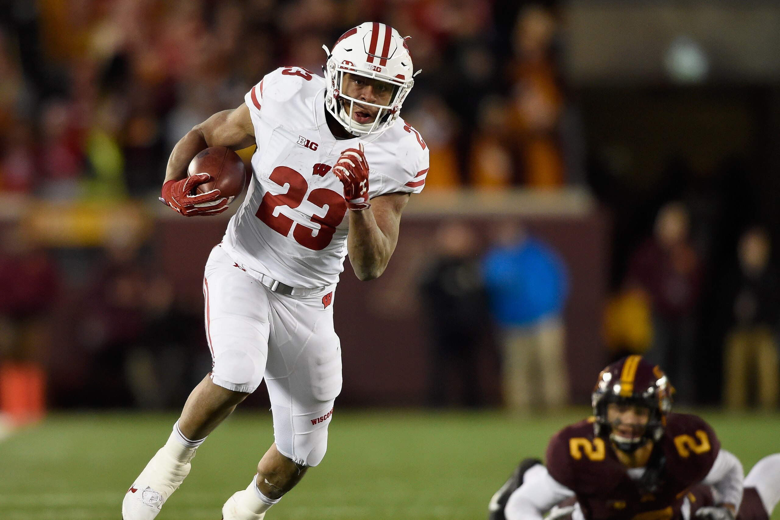 MINNEAPOLIS, MN - NOVEMBER 25: Jonathan Taylor #23 of the Wisconsin Badgers carries the ball for a touchdown after avoiding a tackle by Jacob Huff #2 of the Minnesota Golden Gophers during the fourth quarter of the game on November 25, 2017 at TCF Bank St
