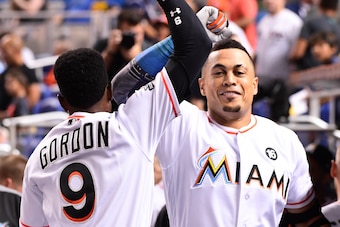 MIAMI, FL - AUGUST 15: Giancarlo Stanton #27 of the Miami Marlins celebrates with Dee Gordon #9 in the dugout after hitting a homerun in the third inning during the game between the Miami Marlins and the San Francisco Giants at Marlins Park on August 15, 