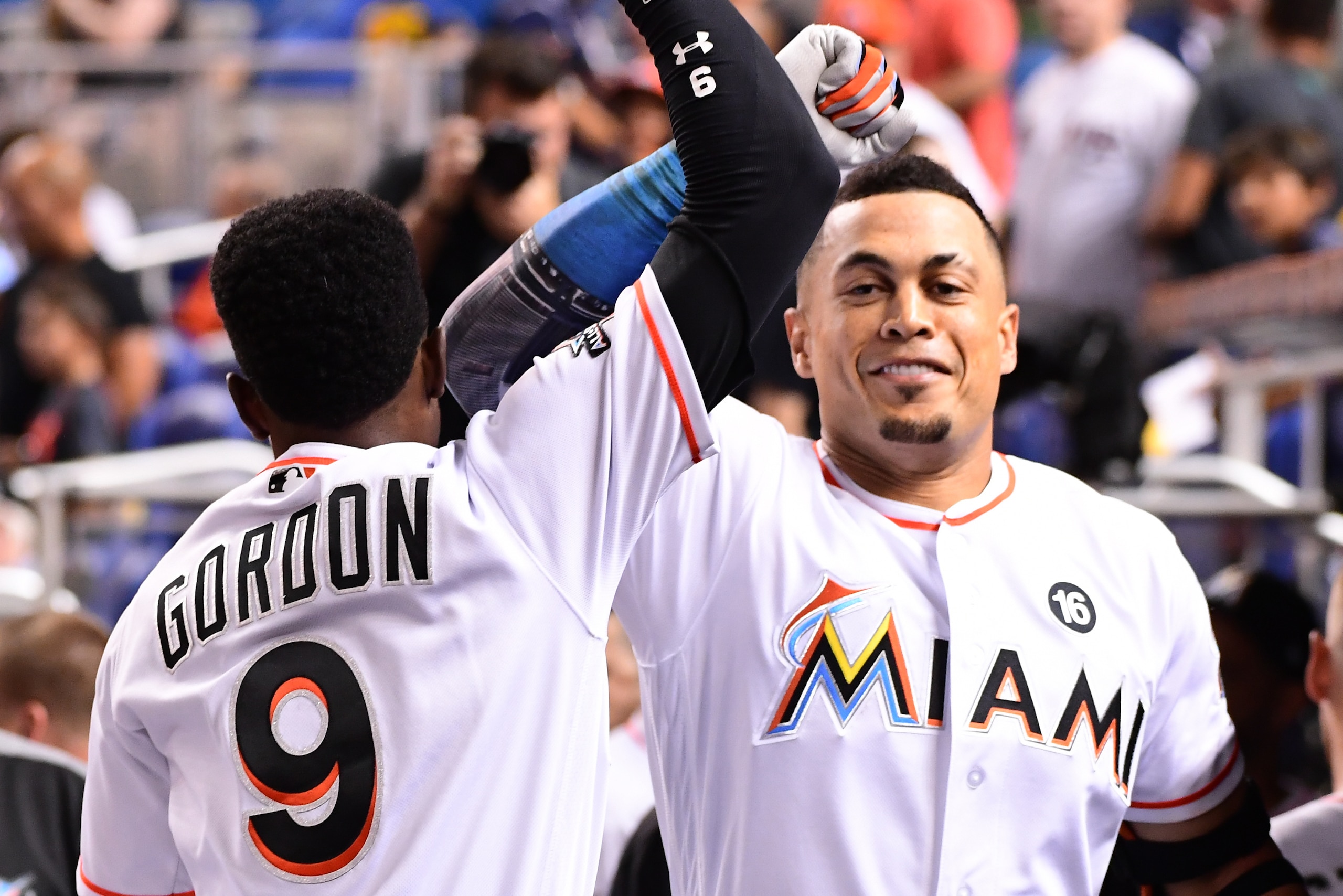 MIAMI, FL - AUGUST 15: Giancarlo Stanton #27 of the Miami Marlins celebrates with Dee Gordon #9 in the dugout after hitting a homerun in the third inning during the game between the Miami Marlins and the San Francisco Giants at Marlins Park on August 15, 