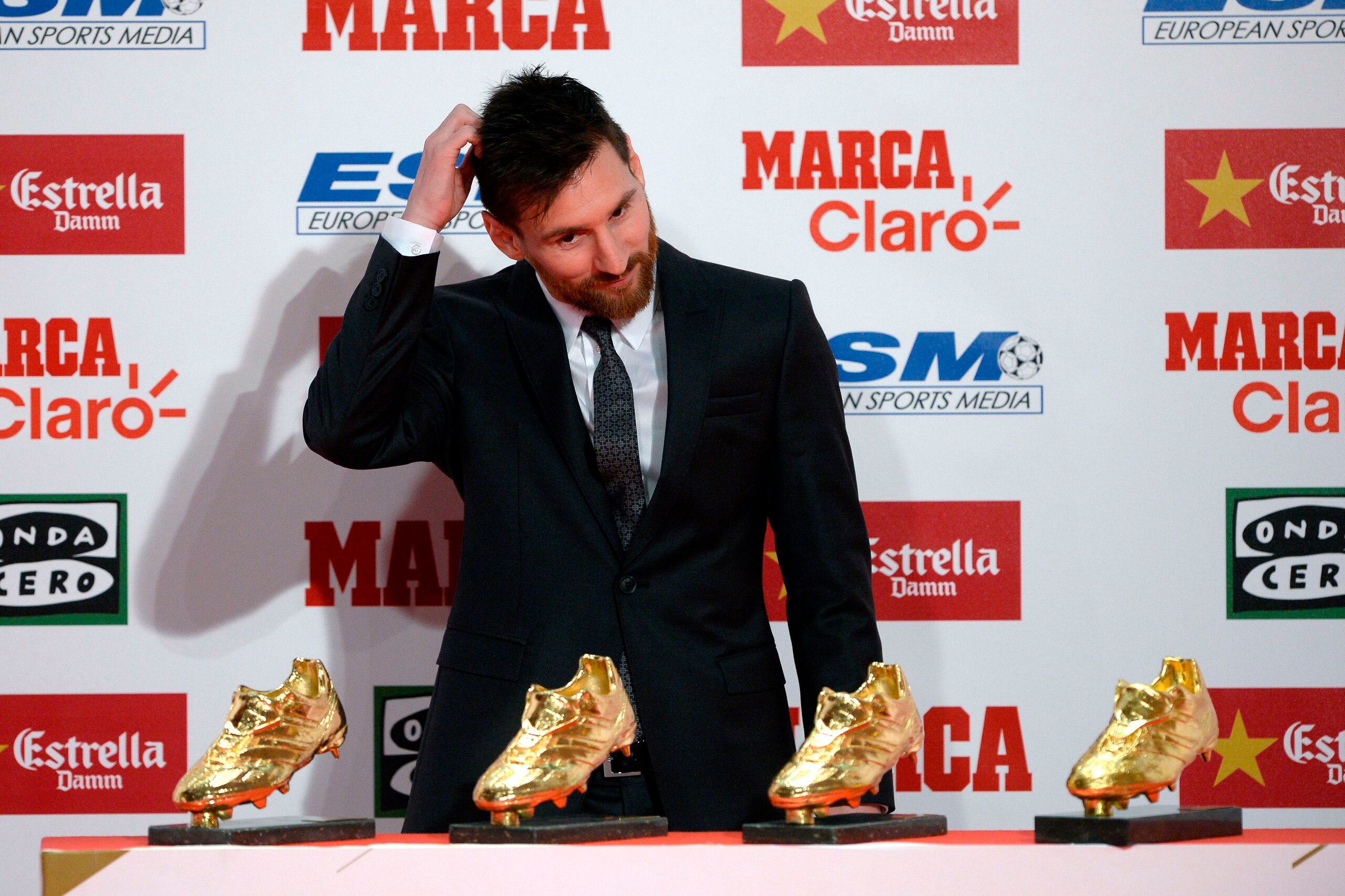 Barcelona's Argentinian forward Lionel Messi reacts next to his four Golden Shoe awards after receiving the 2017 European Golden Shoe honoring the year's leading goalscorer during a ceremony at the Antigua Fabrica Estrella Damm in Barcelona on November 24