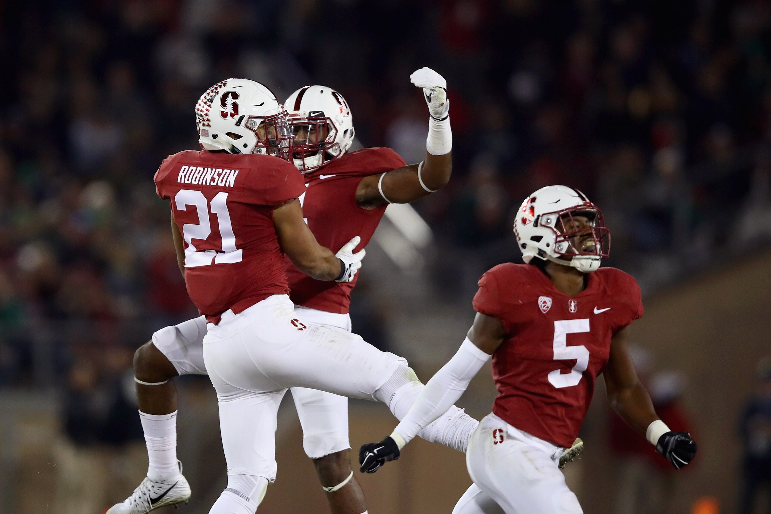 PALO ALTO, CA - NOVEMBER 25:  Curtis Robinson #21 of the Stanford Cardinal celebrates with Alameen Murphy #4 and Frank Buncom #5 after Robinson intercepted a pass against the Notre Dame Fighting Irish at Stanford Stadium on November 25, 2017 in Palo Alto,