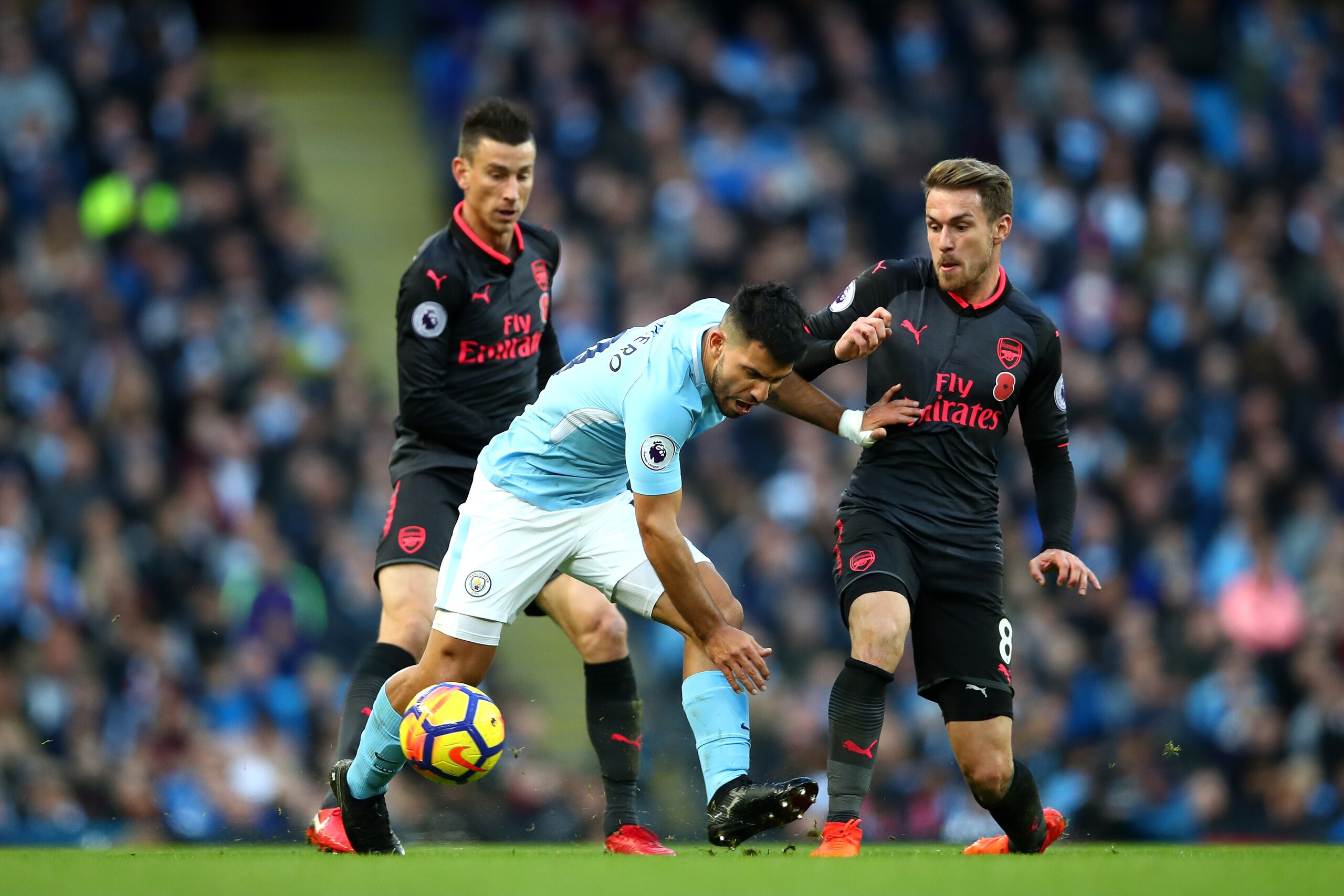 MANCHESTER, ENGLAND - NOVEMBER 05: Laurent Koscielny of Arsenal and Aaron Ramsey of Arsenal battle for possession with Sergio Aguero of Manchester City during the Premier League match between Manchester City and Arsenal at Etihad Stadium on November 5, 20