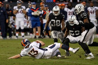OAKLAND, CA - NOVEMBER 26: Quarterback Trevor Siemian #13 of the Denver Broncos slides after rushing for a 5-yard gain during the fourth quarter of his NFL football game against the Oakland Raiders at Oakland-Alameda County Coliseum on November 26, 2017 i