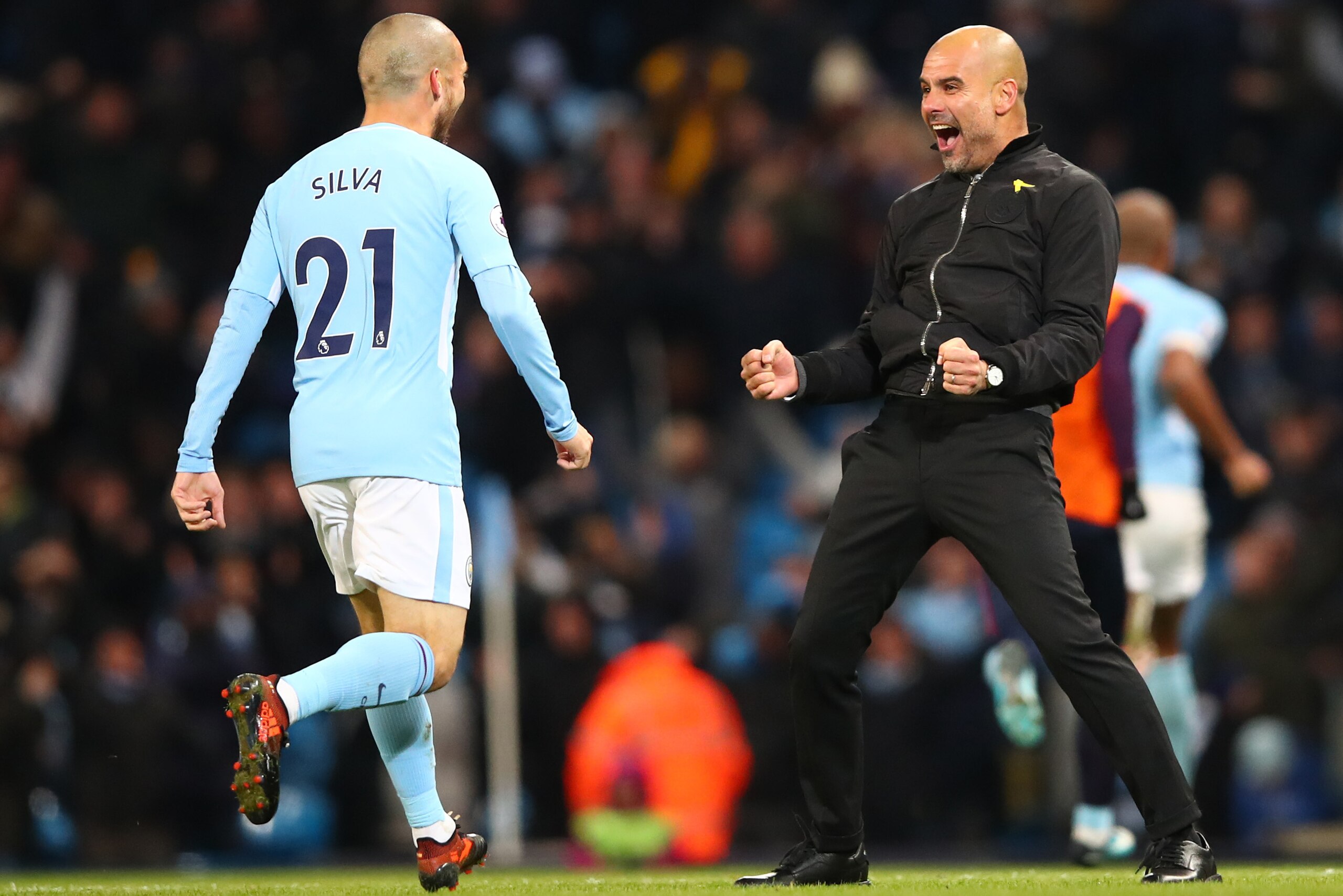 MANCHESTER, ENGLAND - NOVEMBER 29: Josep Guardiola, Manager of Manchester City celebrates his sides second goal with David Silva of Manchester City during the Premier League match between Manchester City and Southampton at Etihad Stadium on November 29, 2