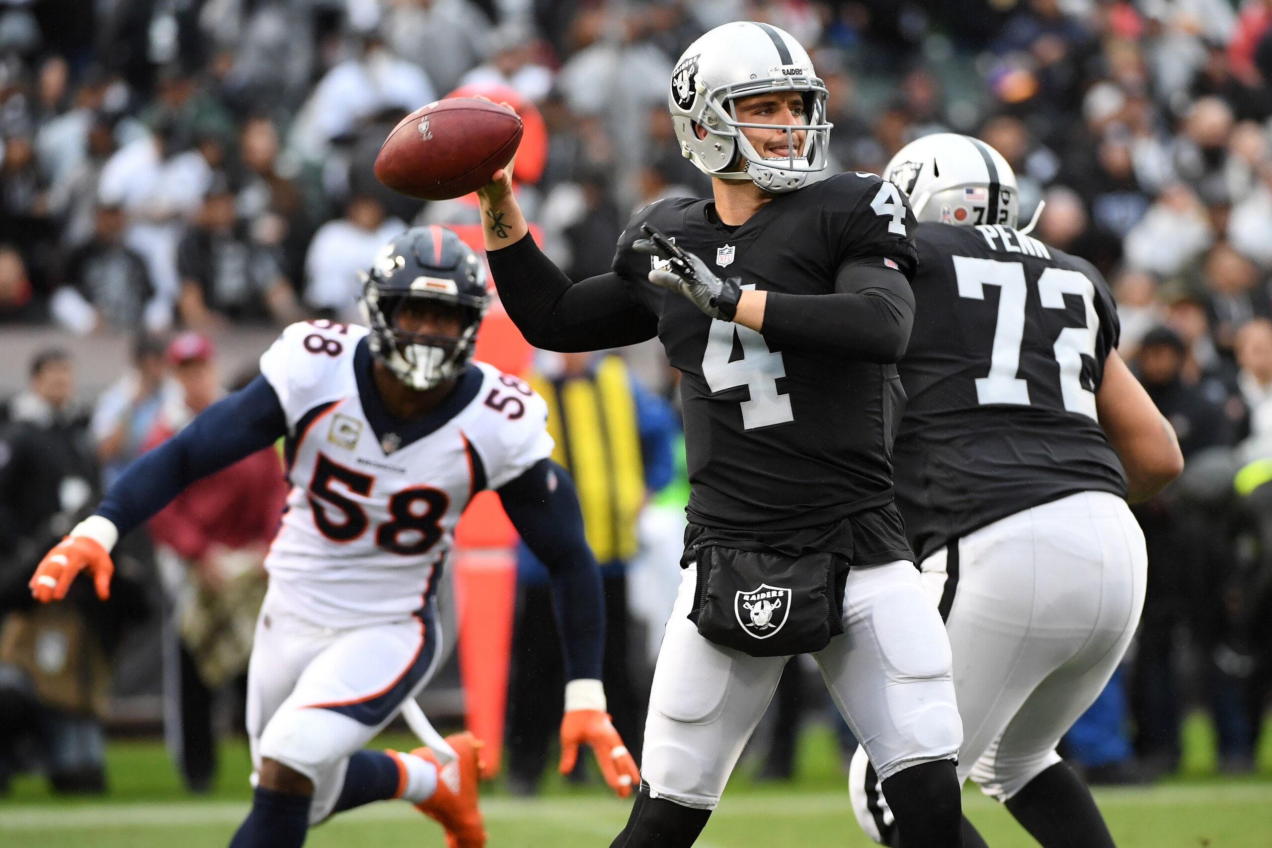 OAKLAND, CA - NOVEMBER 26:  Derek Carr #4 of the Oakland Raiders looks to pass against the Denver Broncos during their NFL game at Oakland-Alameda County Coliseum on November 26, 2017 in Oakland, California.  (Photo by Robert Reiners/Getty Images)