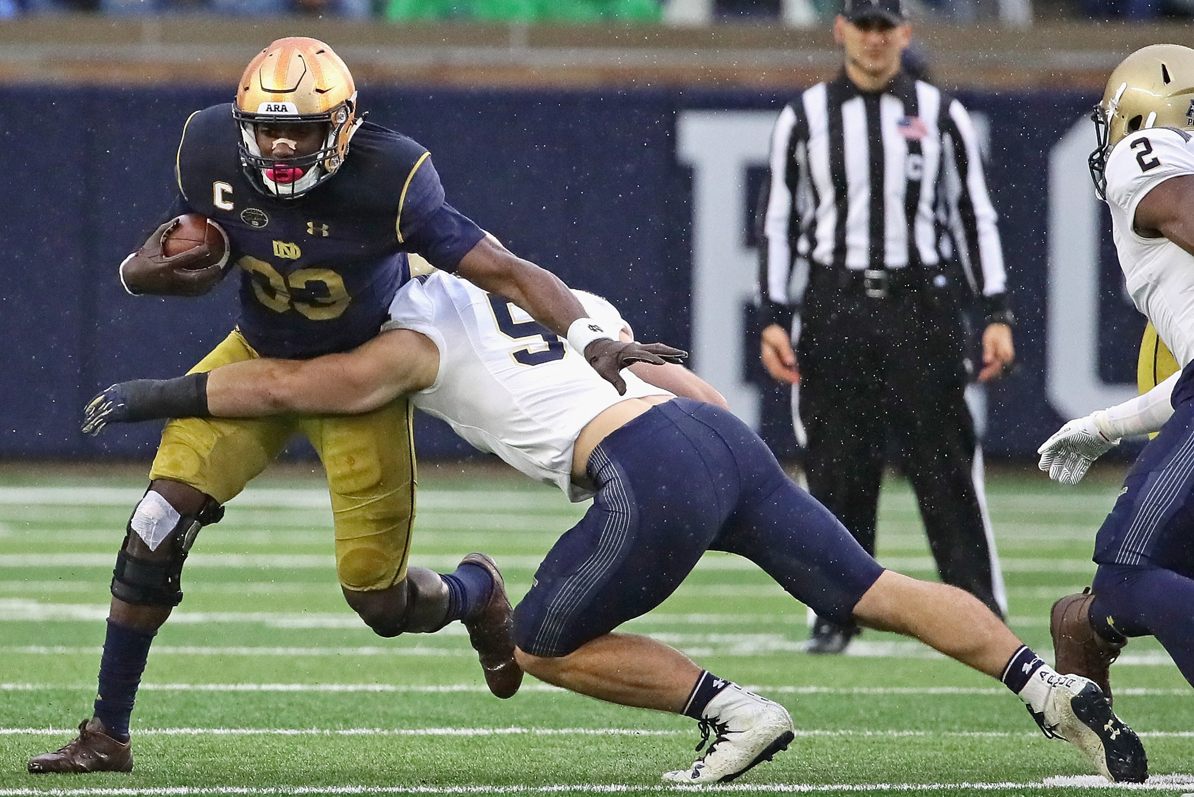 SOUTH BEND, IN - NOVEMBER 18:   Josh Adams #33 of the Notre Dame Fighting Irish gets around Winn Howard #51 of the Navy Midshipmen at Notre Dame Stadium on November 18, 2017 in South Bend, Indiana. (Photo by Jonathan Daniel/Getty Images)