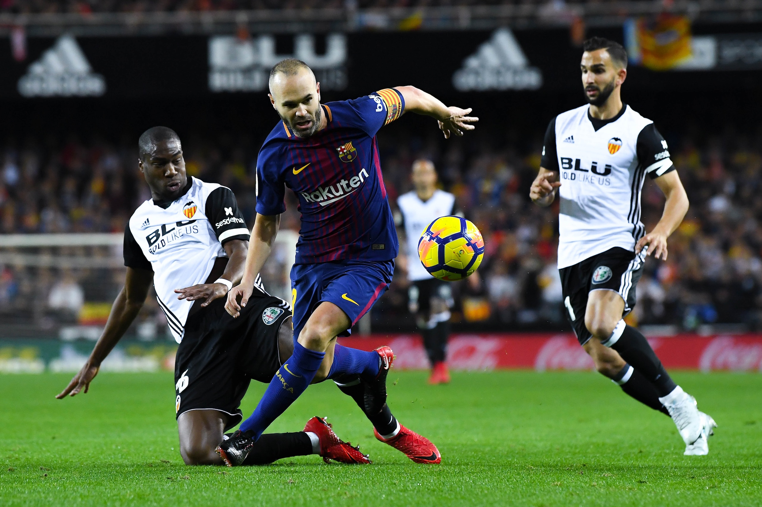 VALENCIA, SPAIN - NOVEMBER 26: Andres Iniesta of FC Barcelona competes for the ball with Geoffrey Kondogbia (L) and Martin Montoya of Valencia CF during the La Liga match between Valencia and Barcelona at Mestalla stadium on November 26, 2017 in Valencia VALENCIA, SPAIN - NOVEMBER 26: Andres Iniesta of FC Barcelona competes for the ball with Geoffrey Kondogbia (L) and Martin Montoya of Valencia CF during the La Liga match between Valencia and Barcelona at Mestalla stadium on November 26, 2017 in Valencia
